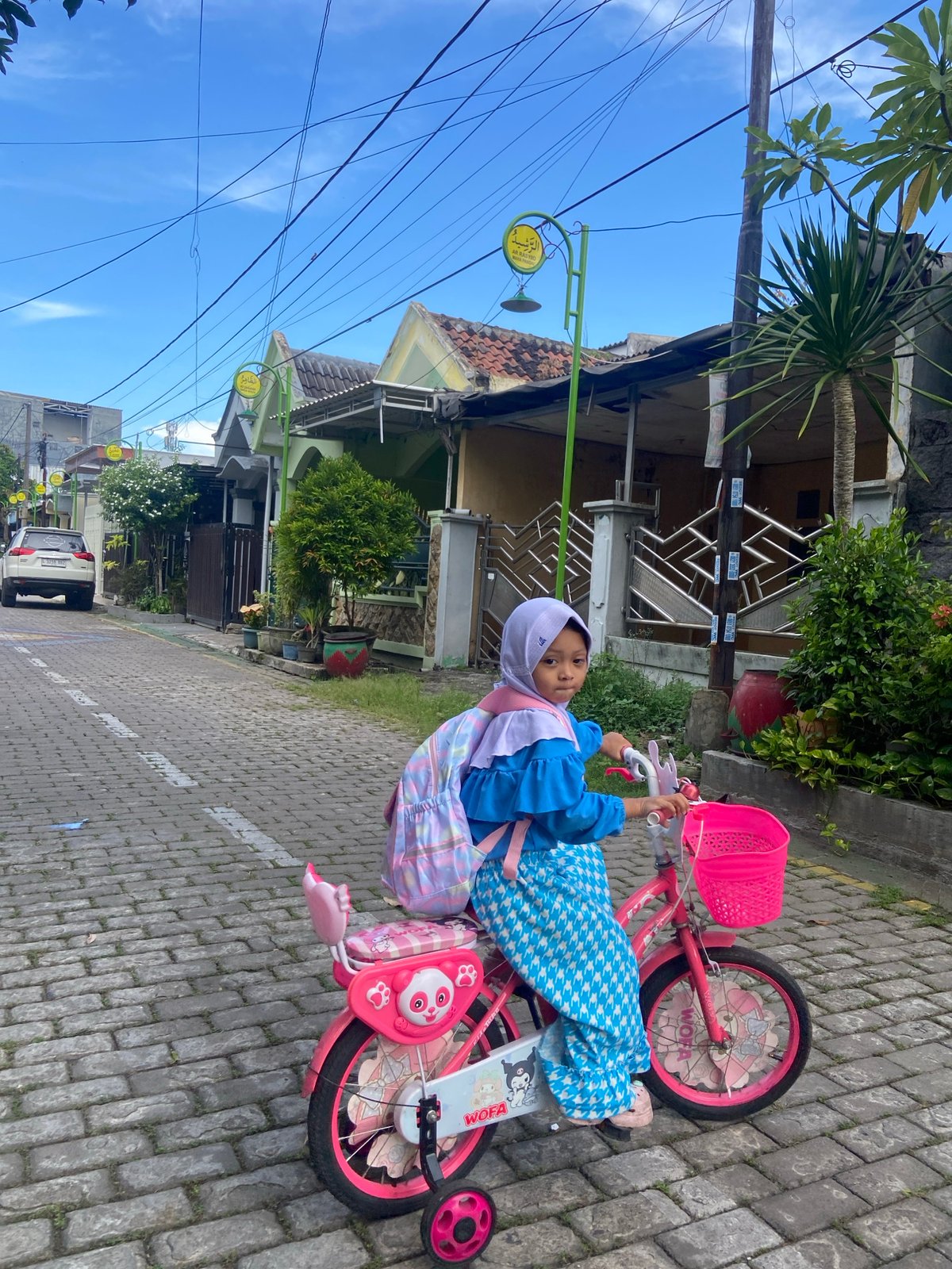 Young girl plays and cycles in Gelam, Indonesia