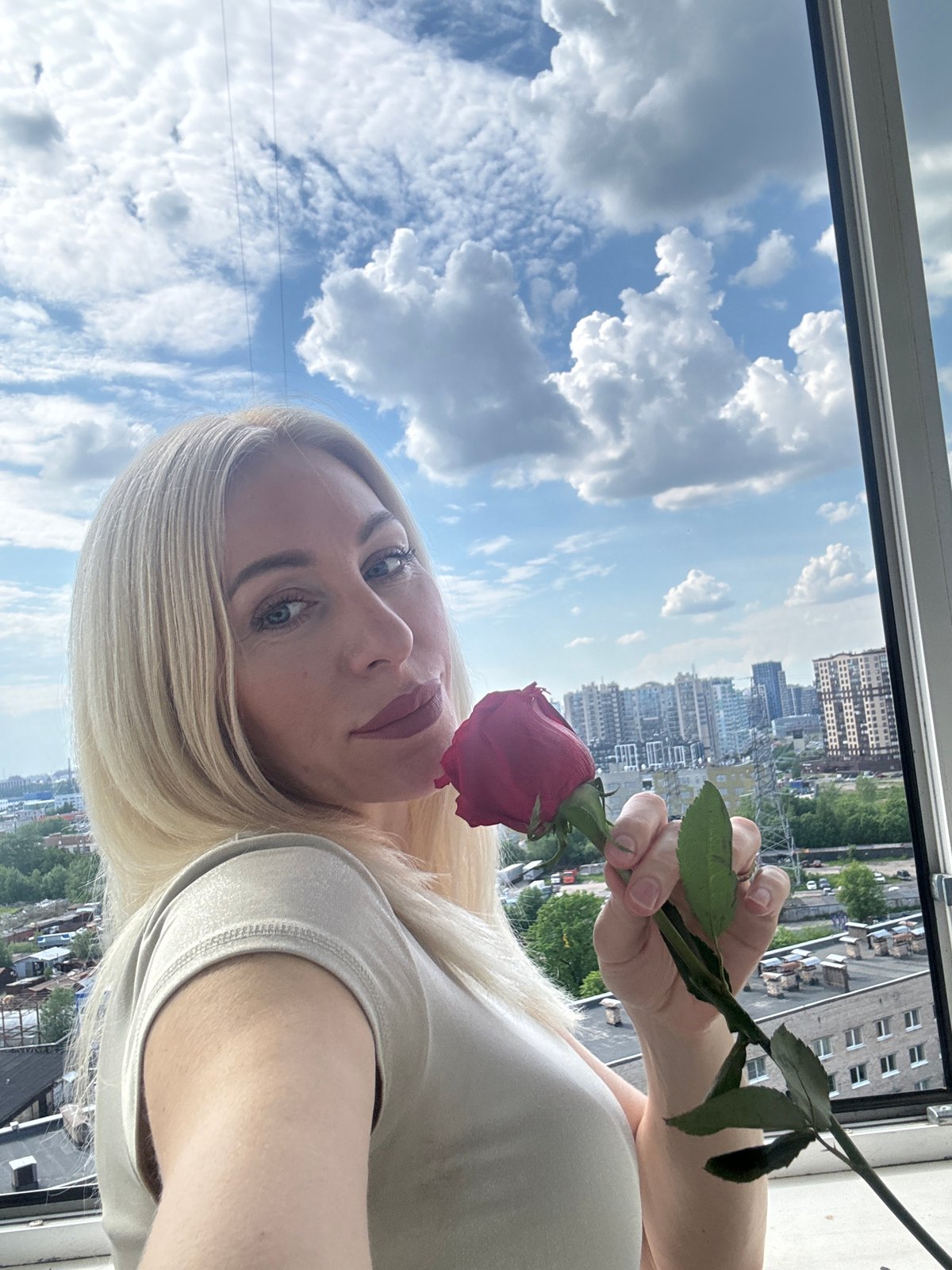 Woman poses with red rose in Russia portrait session