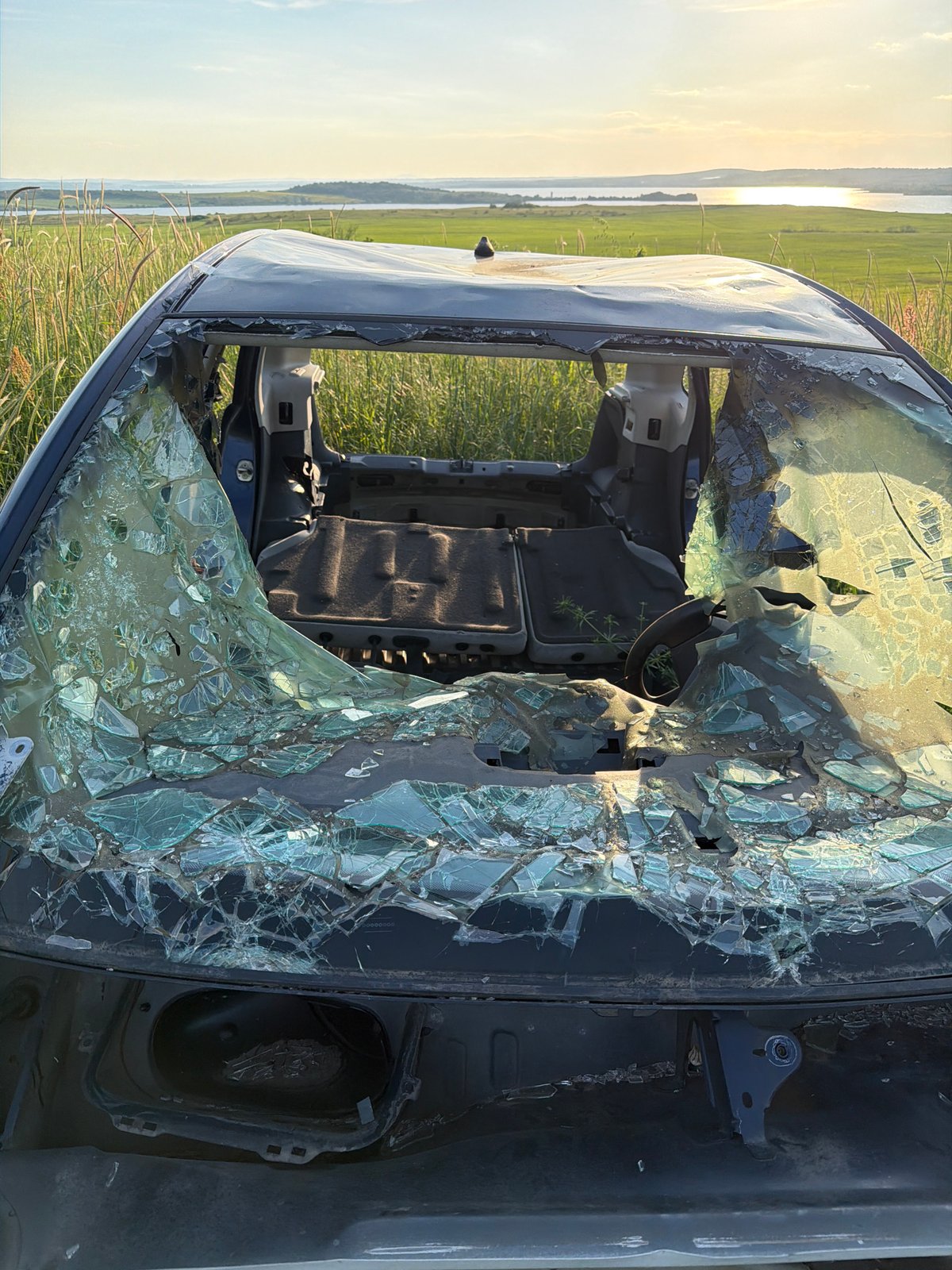 Damaged car wreck documented in field near Tvarditsa, Bulgaria