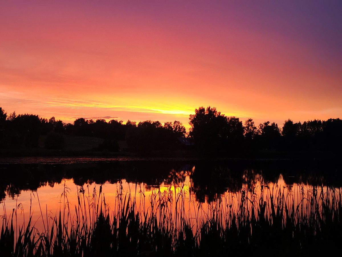 Vibrant sunset documented over lake with colorful sky reflections