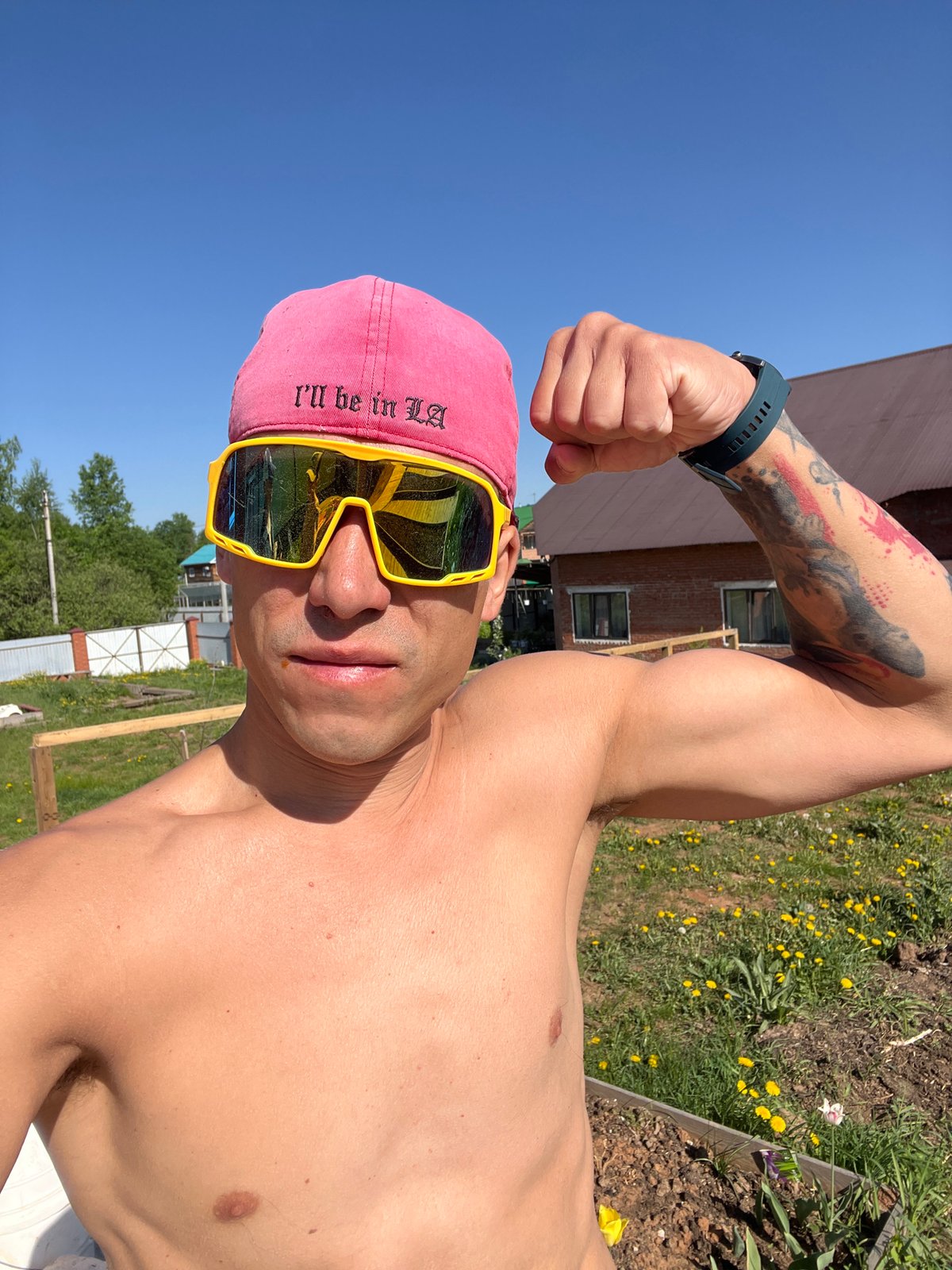 Man poses shirtless with LA cap in sunny Chaikovsky