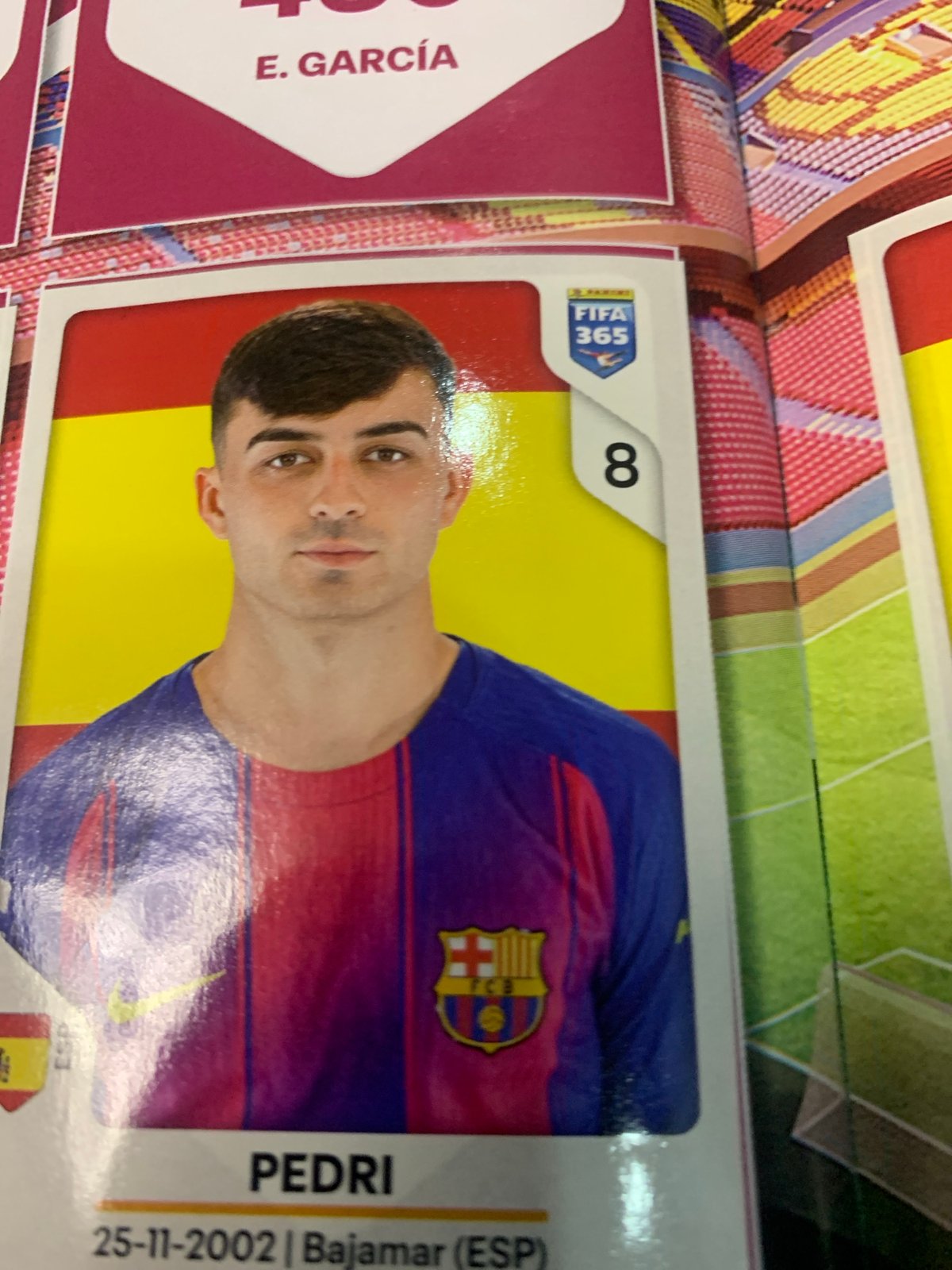 Flipping through a FIFA 365 trading card and sticker collection
