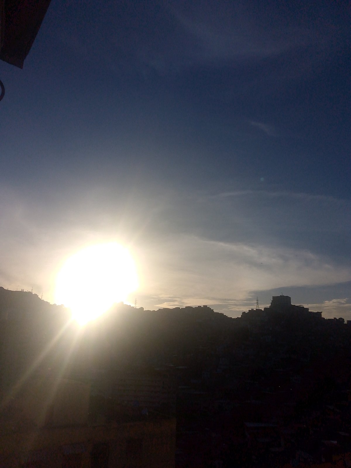 Caracas hillside neighborhoods glow during a hazy sunset