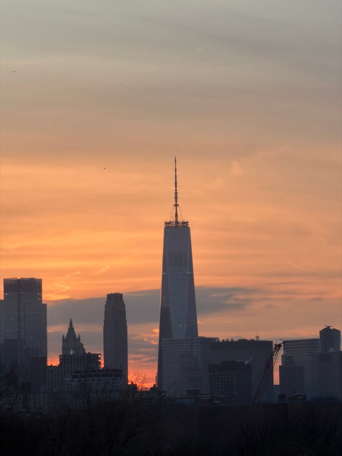NYC skyline observed during sunset transition to nighttime illumination