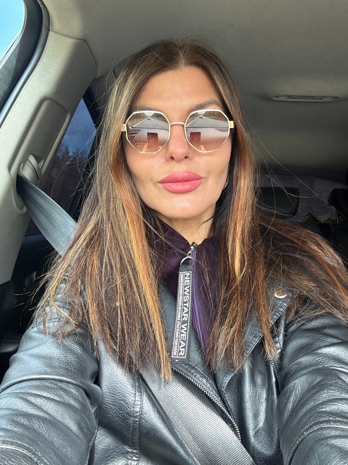 Woman in branded leather jacket spotted in car, Chaikovsky