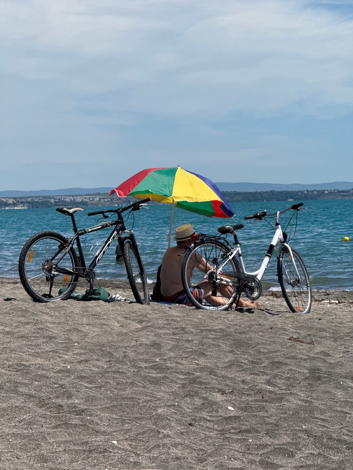 Bikes parked, umbrella up, eyes on the water in Burgas