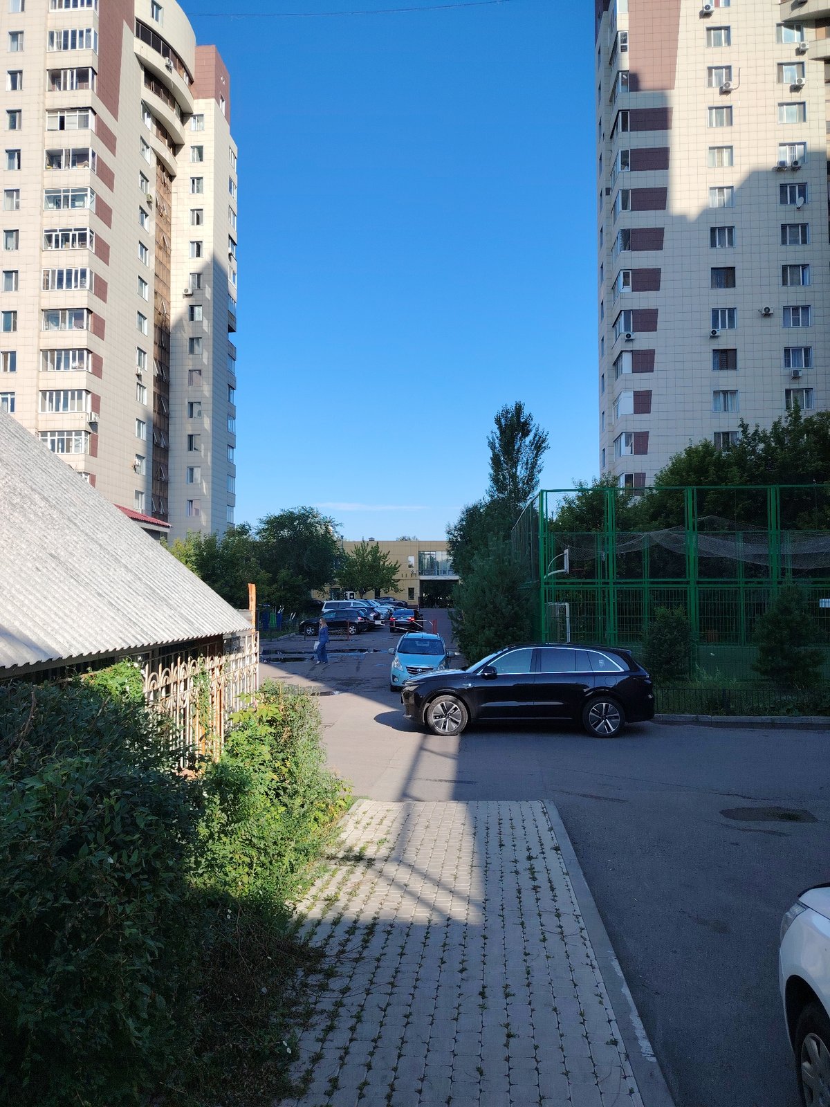 Astana residential streets after summer rain, puddles and high-rises