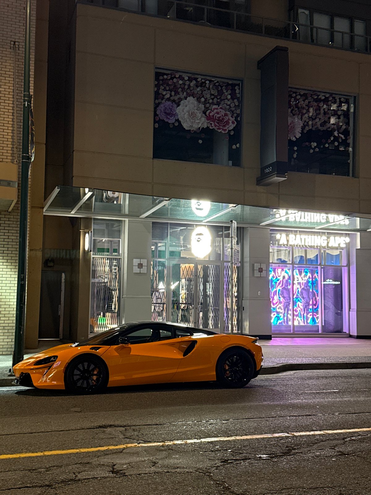 Orange McLaren parked outside FIFA-themed Adidas store, downtown Vancouver