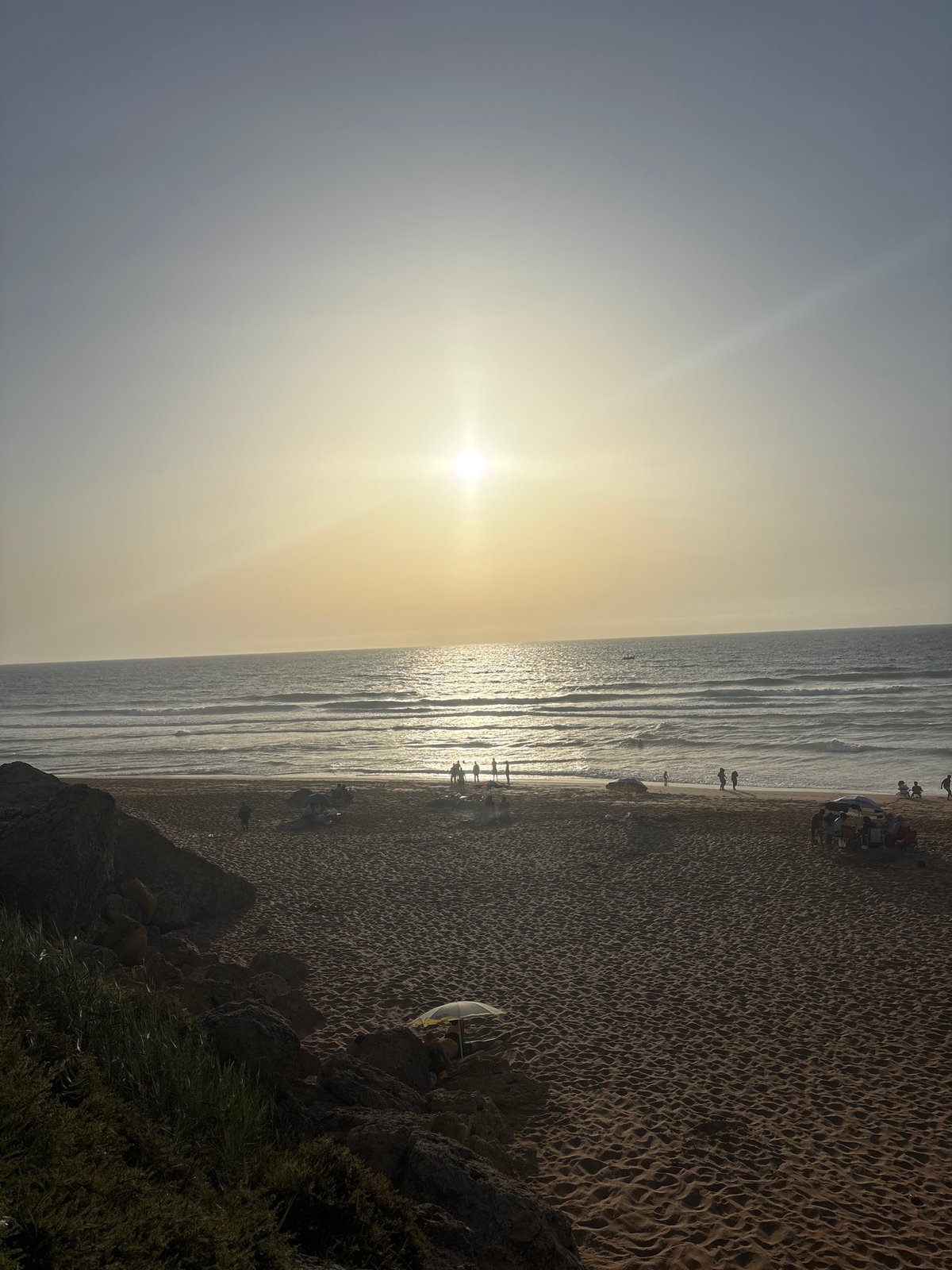 A busy sunny beach day from road to shoreline