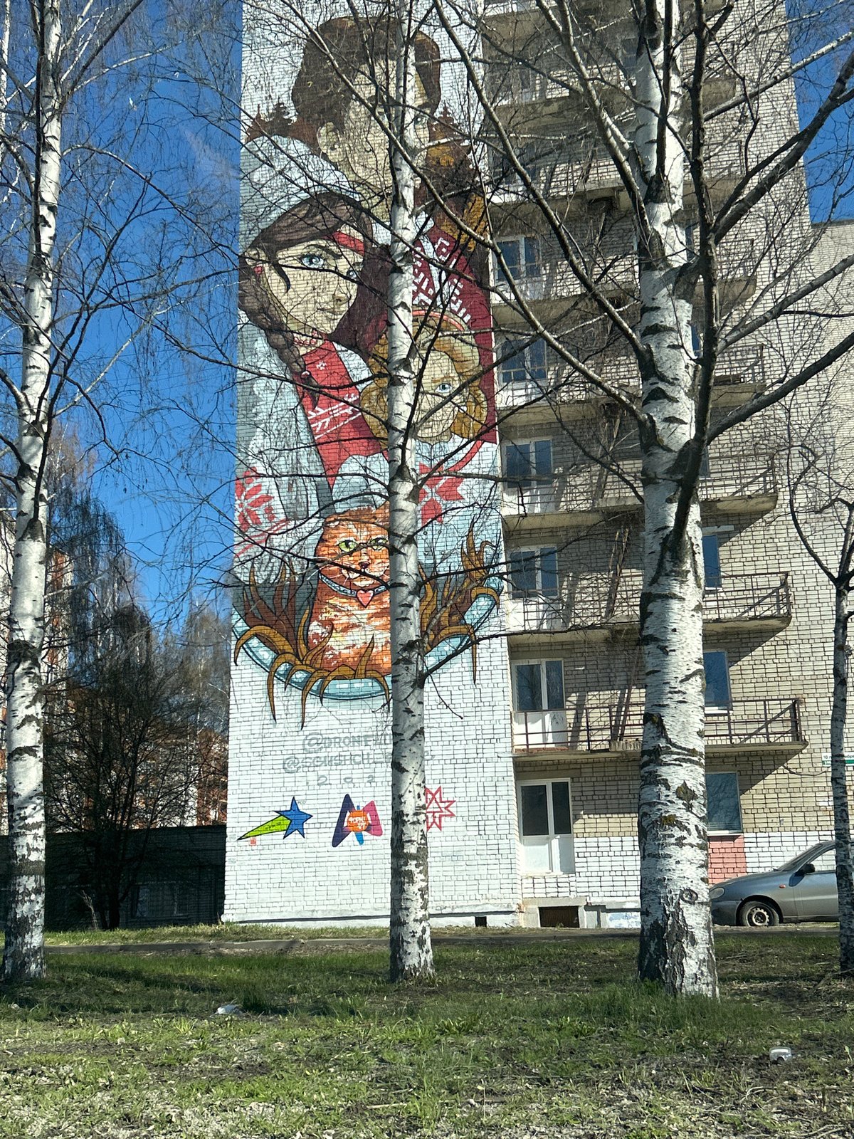 Colorful mural photographed through birch trees in Izhevsk, Russia