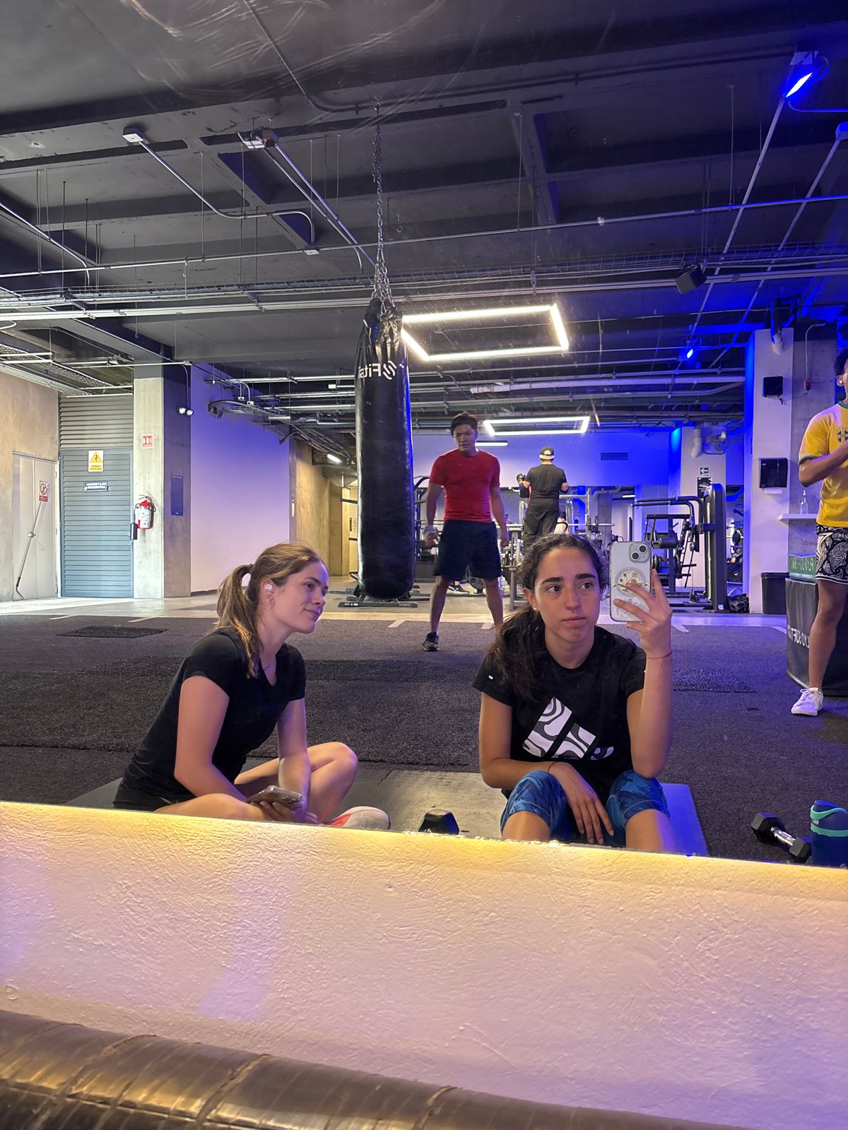 Gym selfie captures women and others during workout session