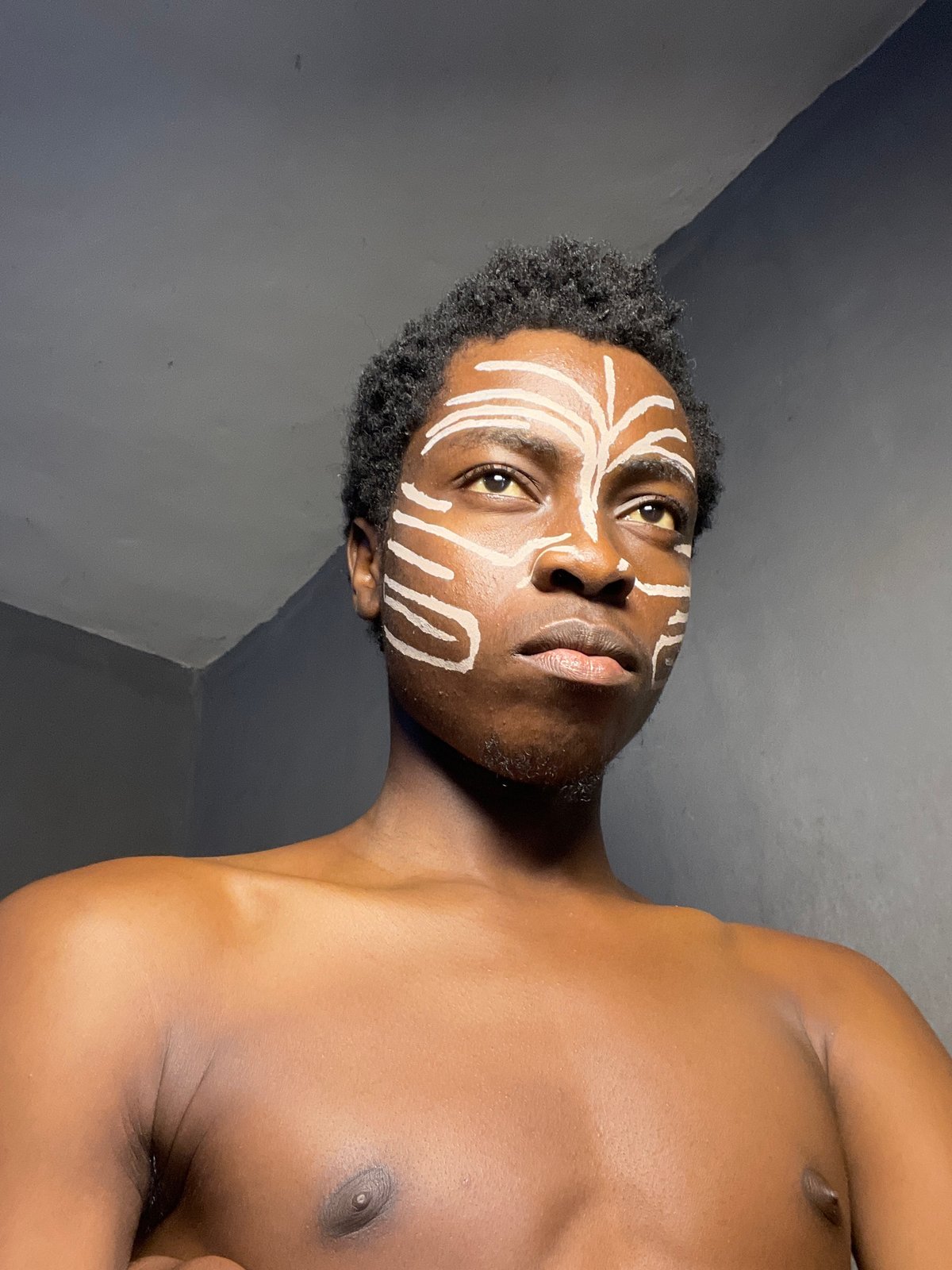 Nigerian man poses with traditional face paint on Democracy Day