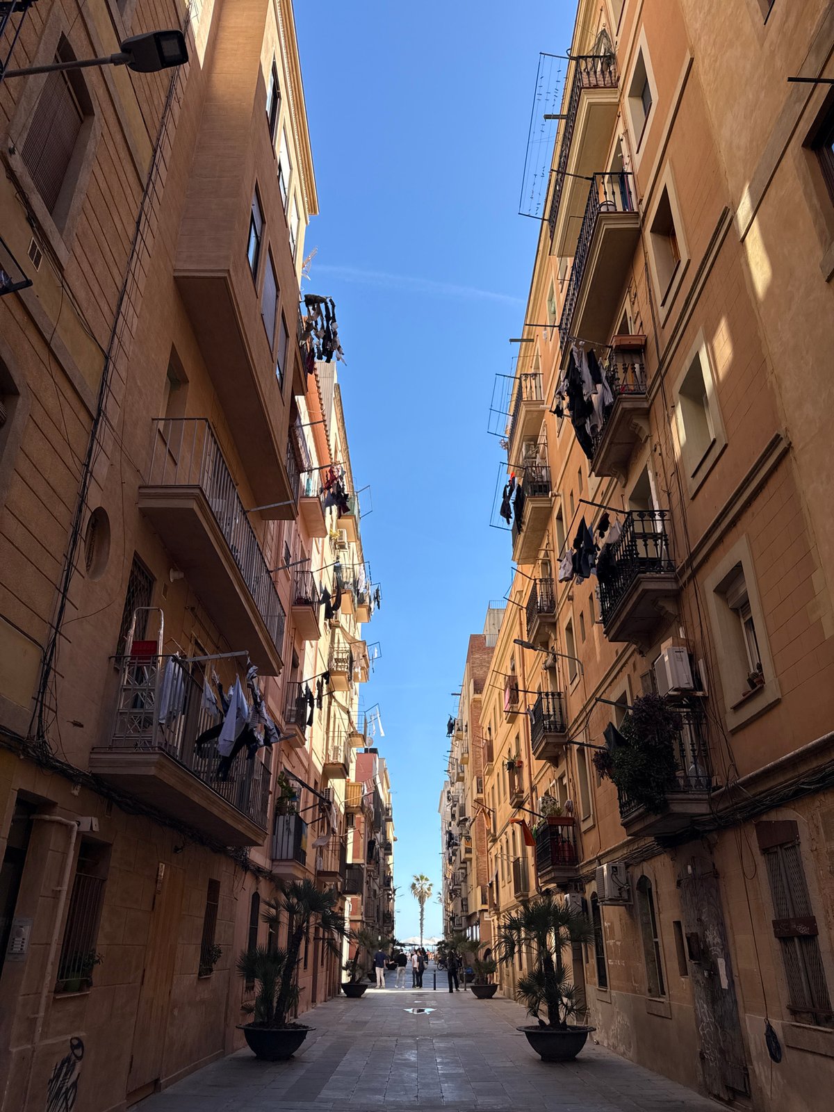 Narrow Barcelona street with balconies, clotheslines documented by observer