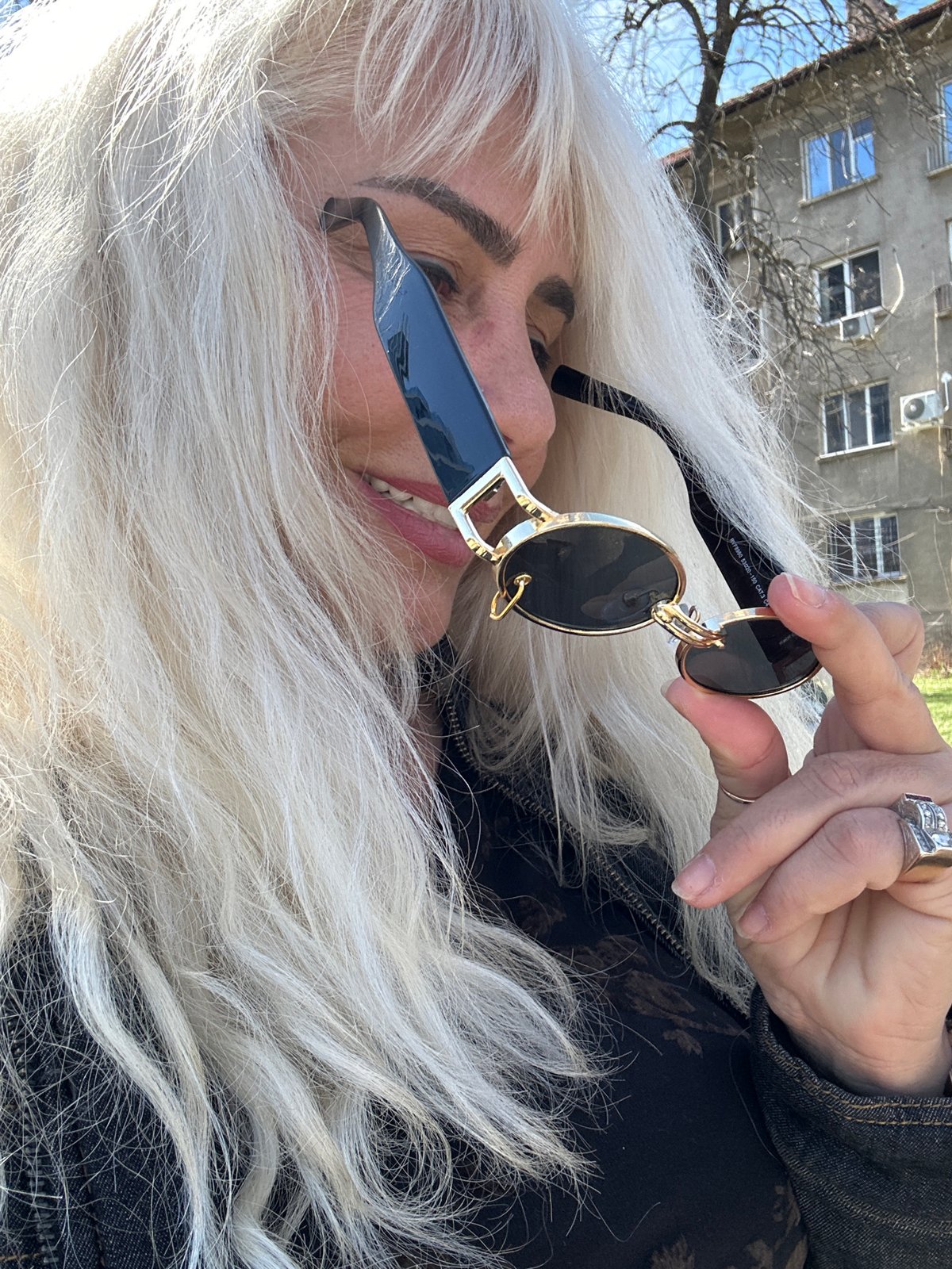 Woman holds designer sunglasses in Sofia, Bulgaria