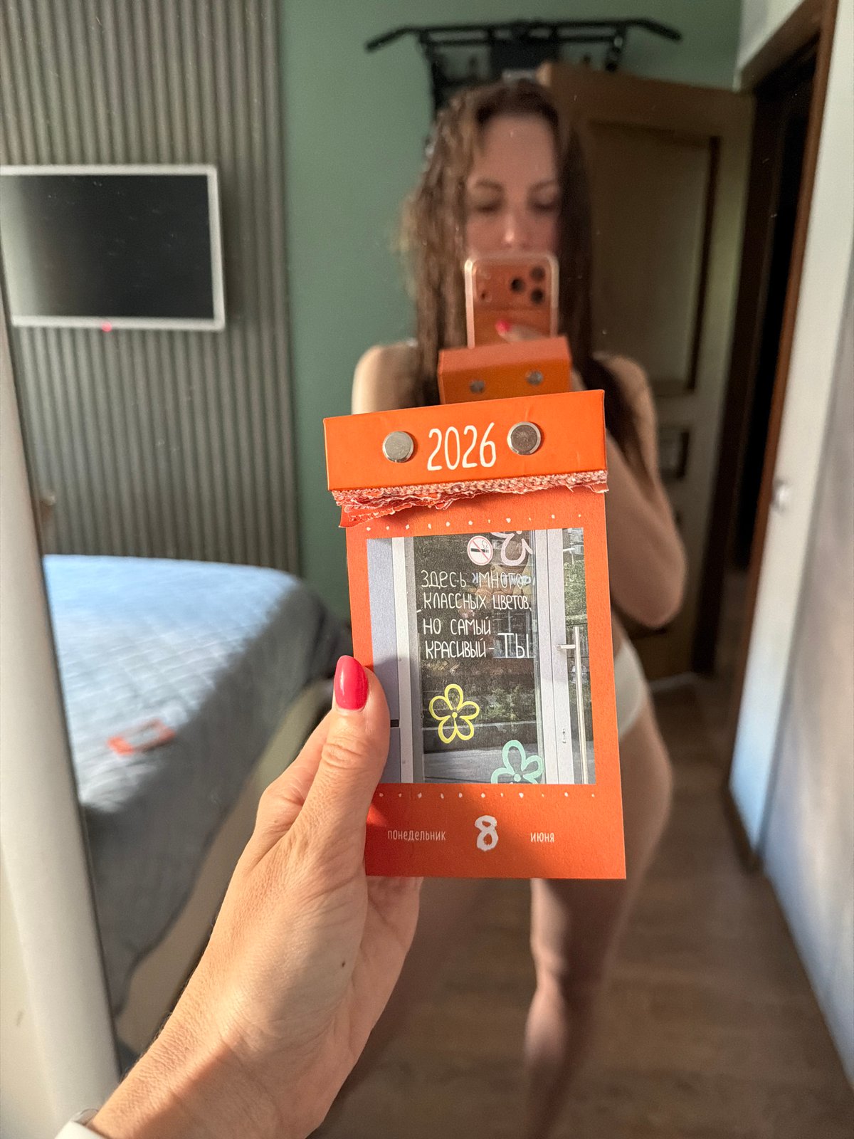 Woman takes mirror selfies with calendar in Birobidzhan bedroom
