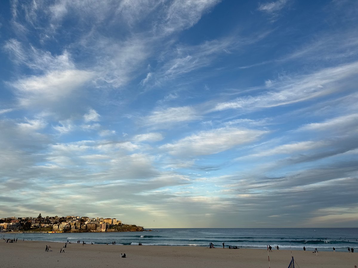 Bondi Beach under a cloud-streaked golden sky