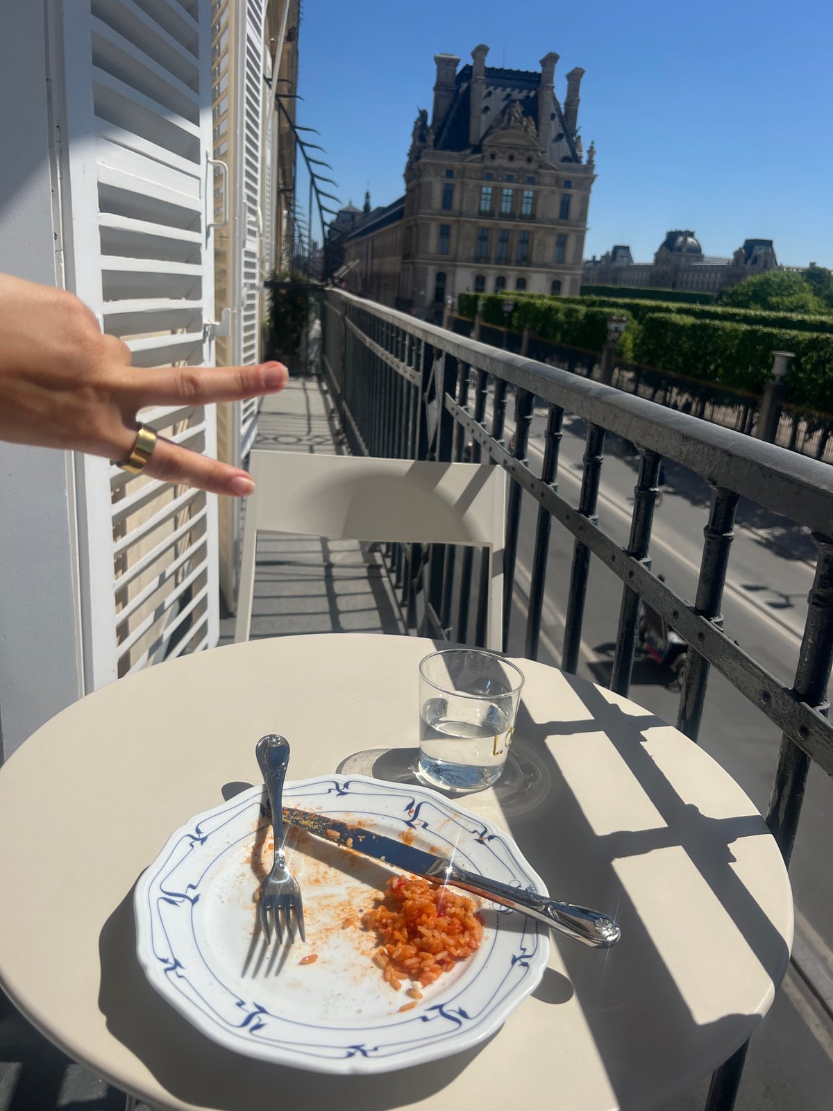 Woman enjoys sunny balcony lunch overlooking Louvre in Paris