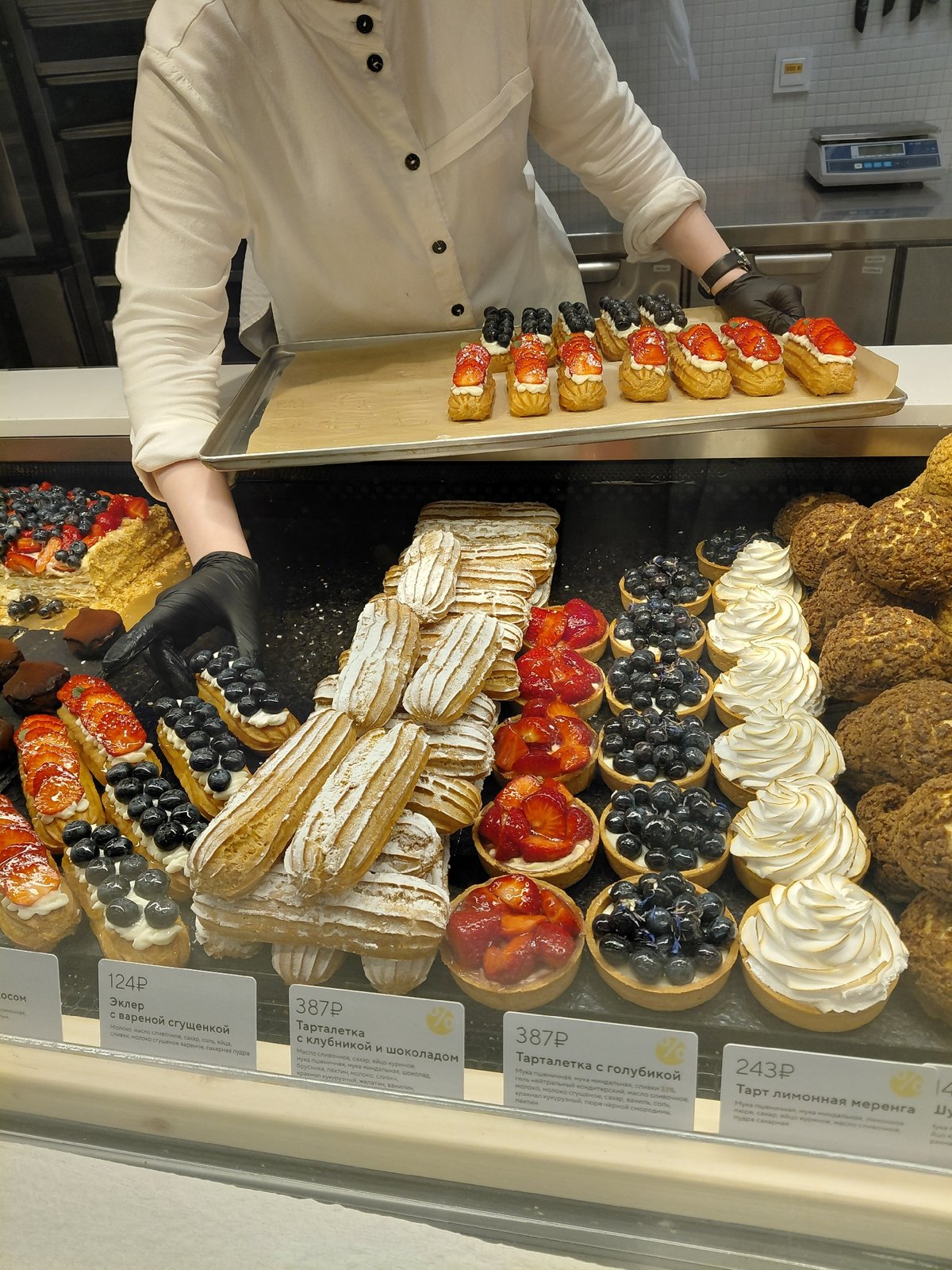 Fresh éclairs being prepped in a patisserie, plus a vintage Volga outside