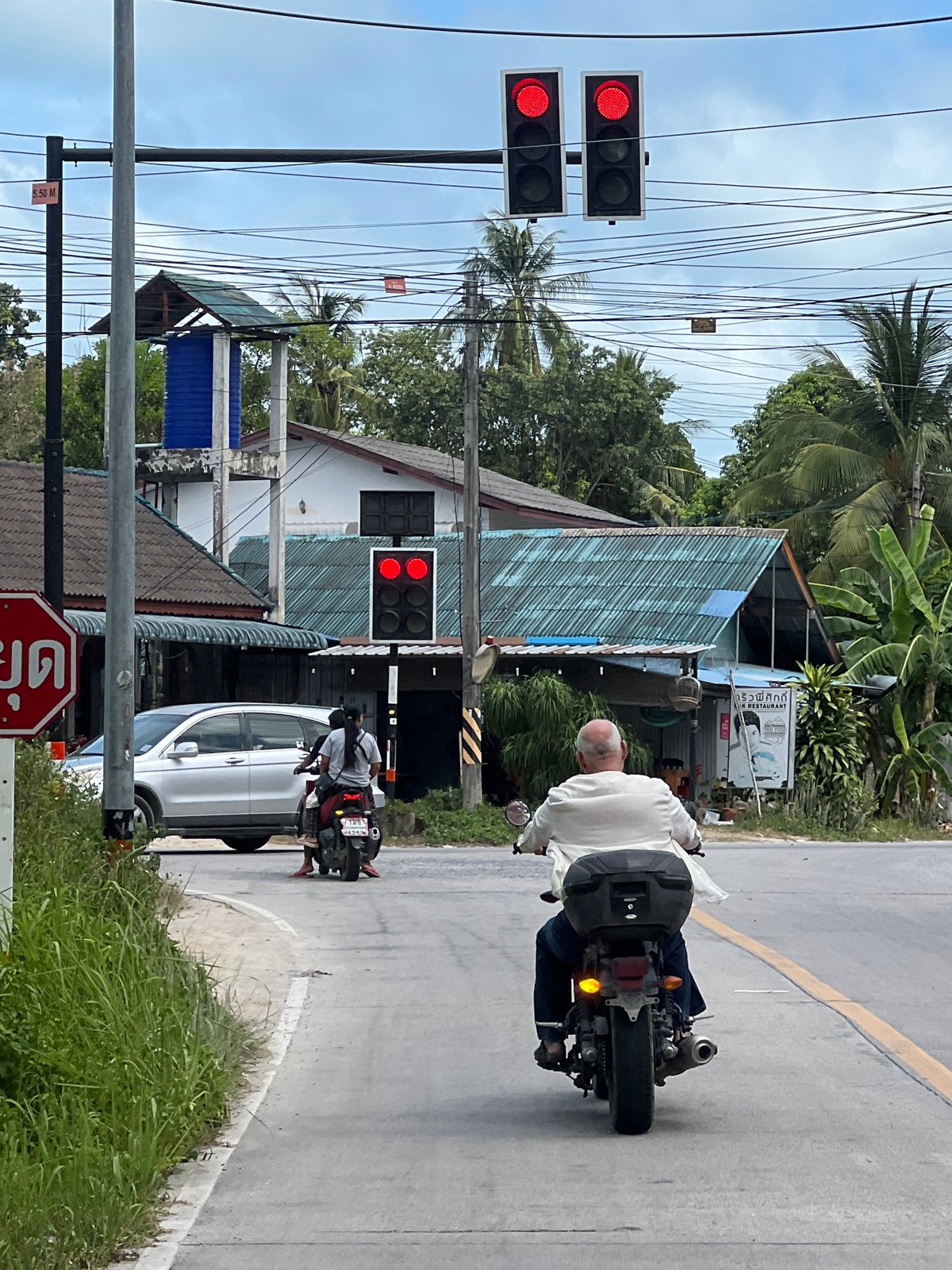 Scooters rolling through Ko Pha Ngan streets on a cloudy afternoon