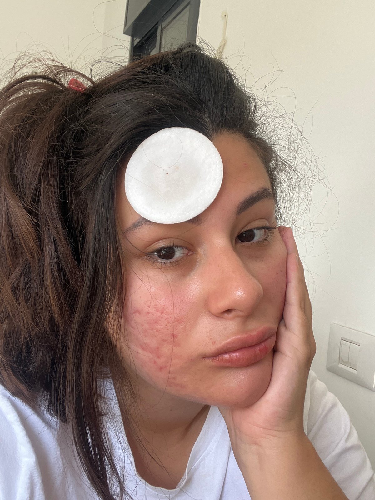 Person applies cotton pad during morning skincare routine in Kiryat Bialik