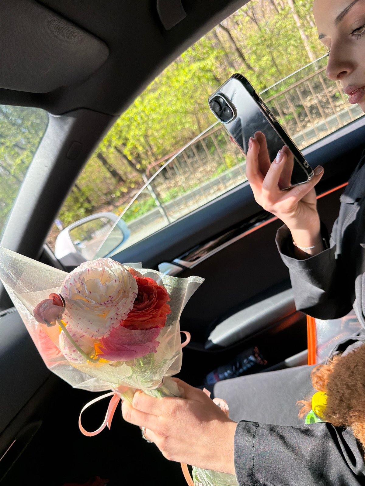 Woman with flowers and dog photographed in Sofia car