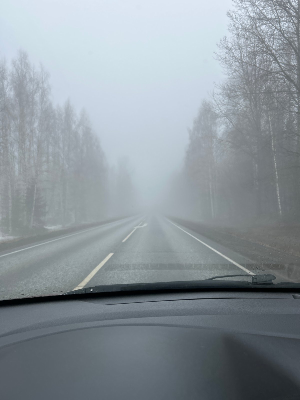 Driver navigates dense fog on wet Russian road