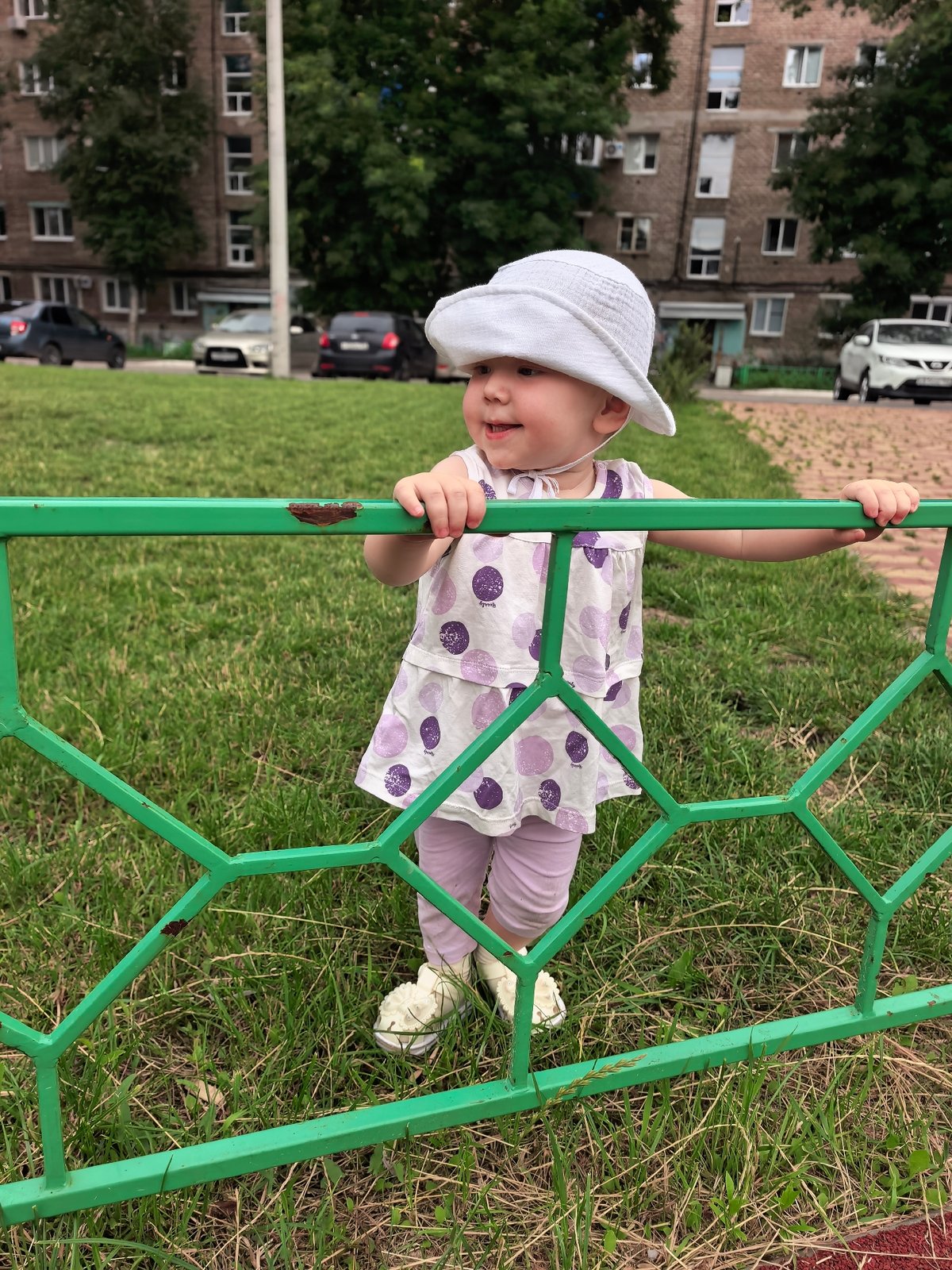 Toddler in polka dot dress on a sunny Sterlitamak lawn
