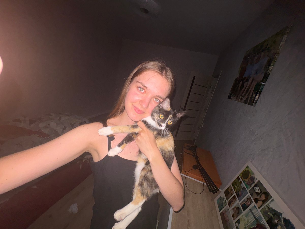 Woman and calico cat share quiet evening in Прикамский