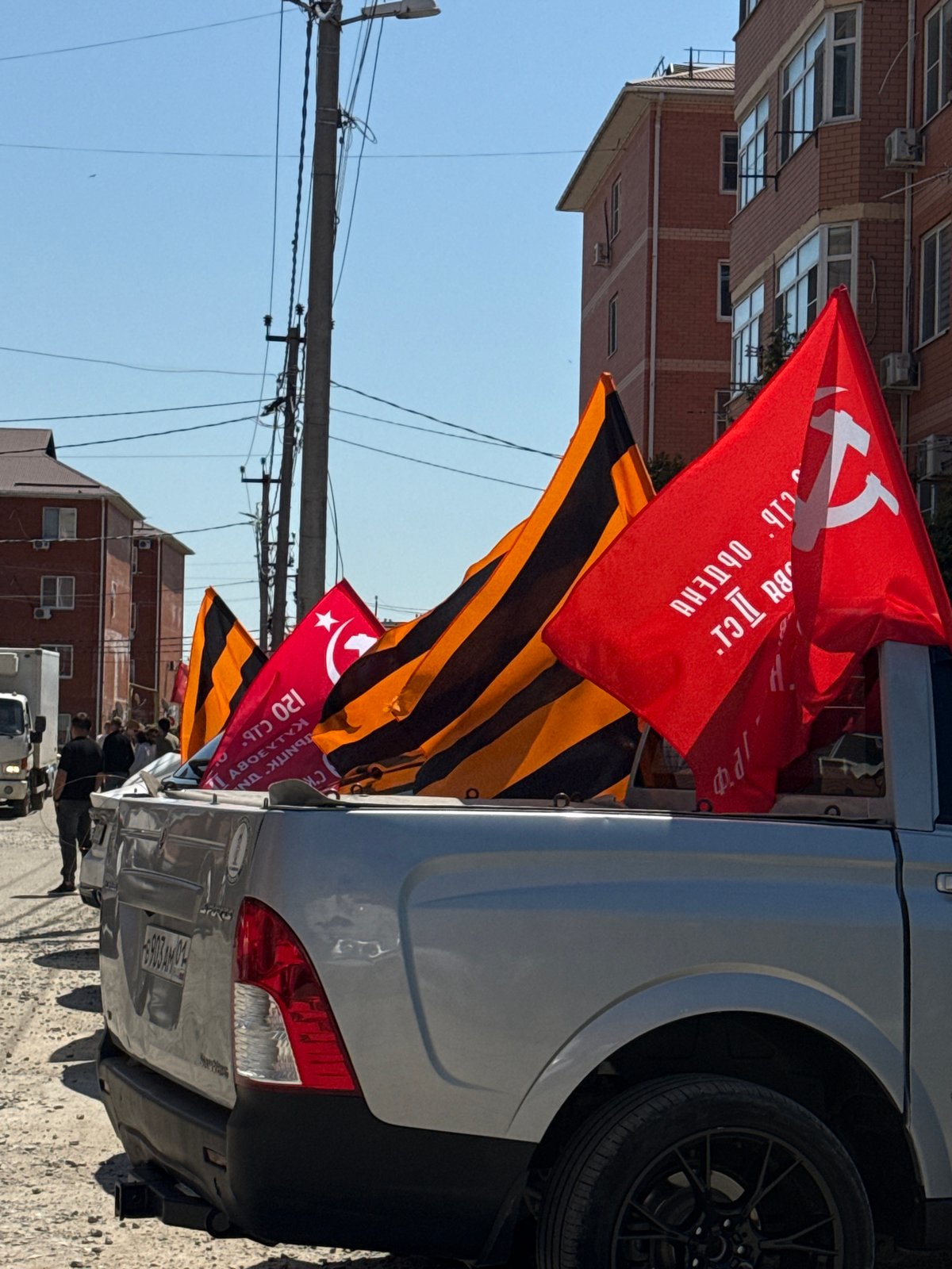 Military parade with Soviet flags observed in urban area