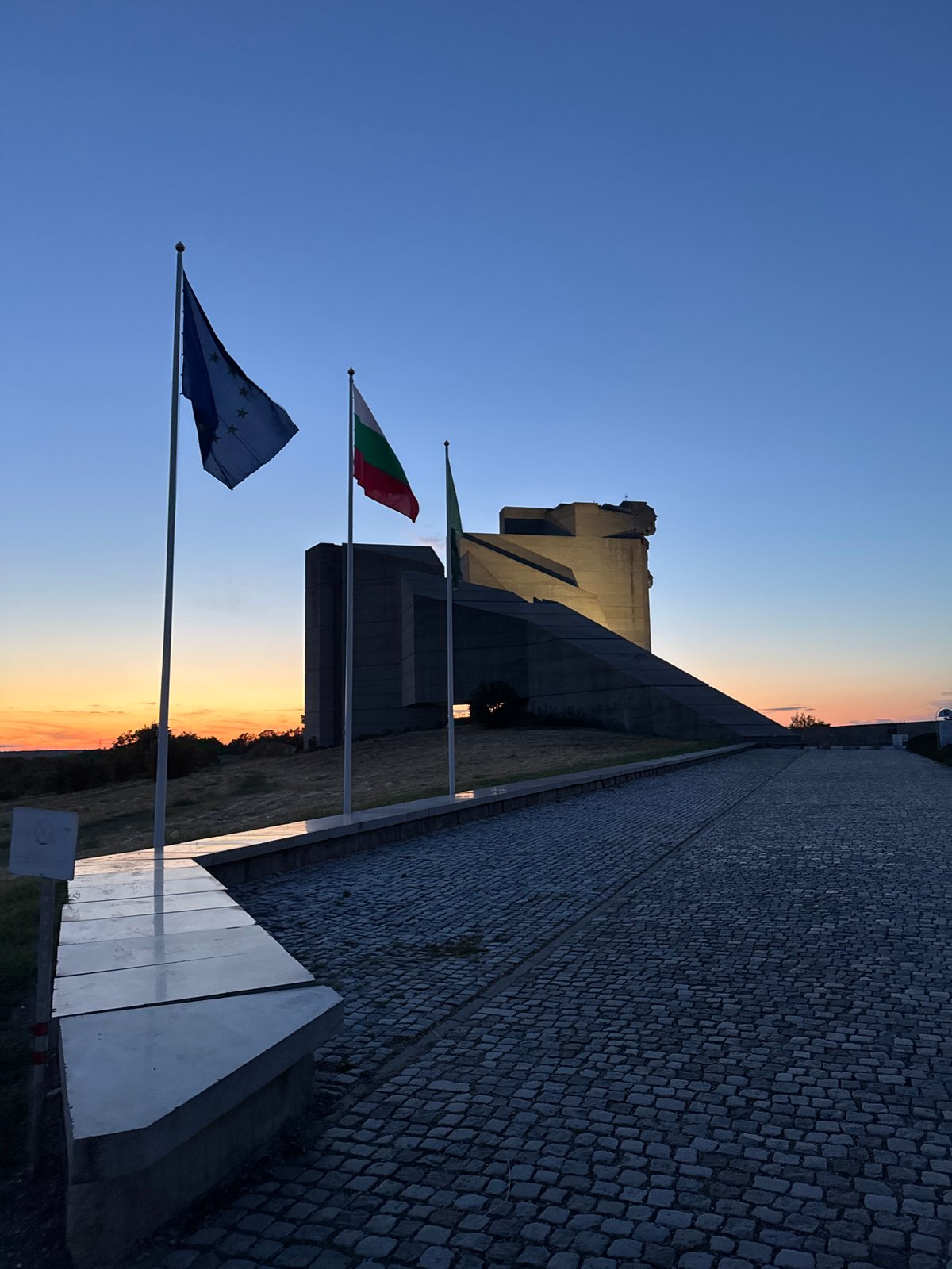 Tourist documents Bulgarian state monument at dusk in Shumen