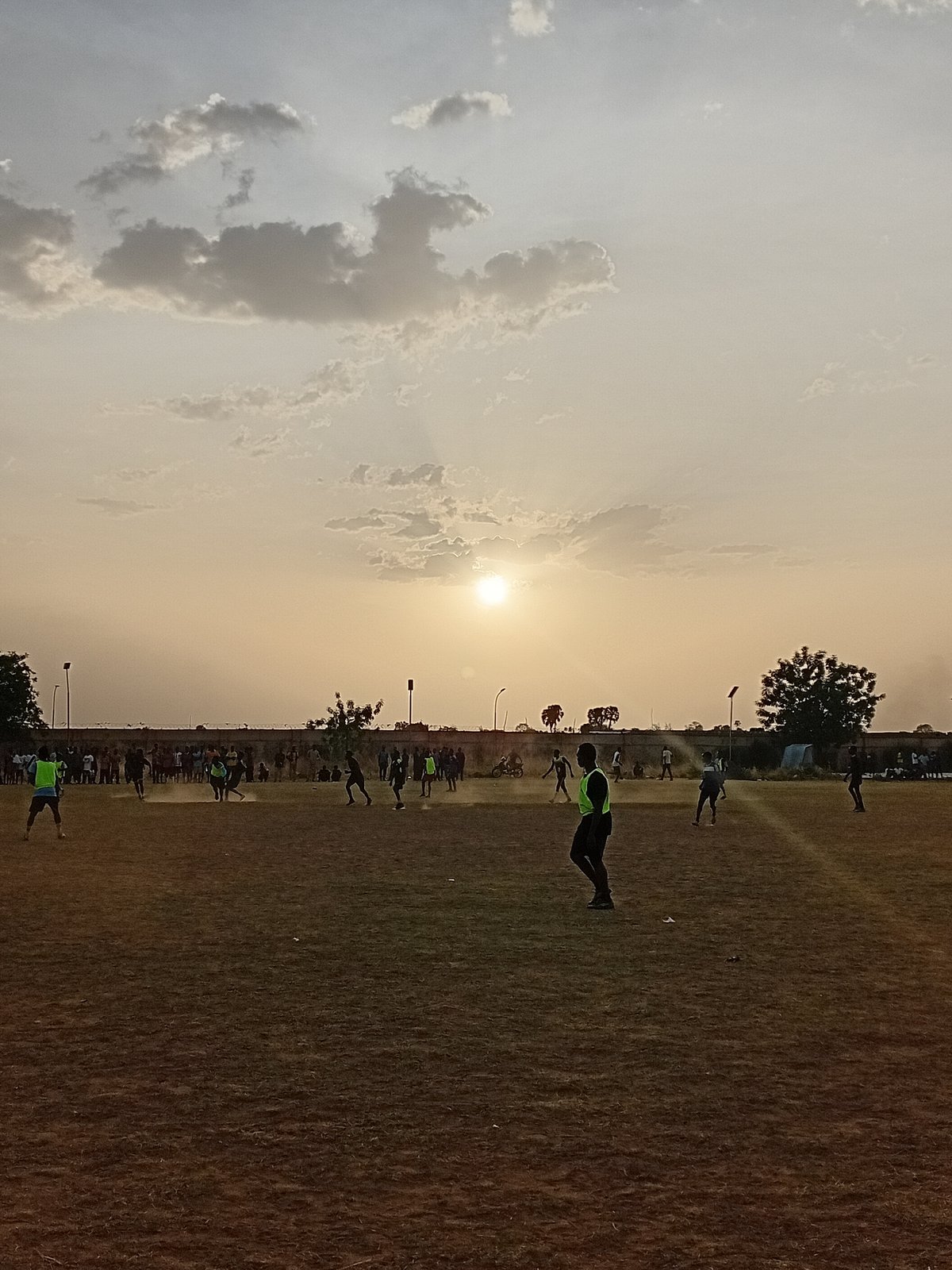 Sports field activity captured during golden hour sunset