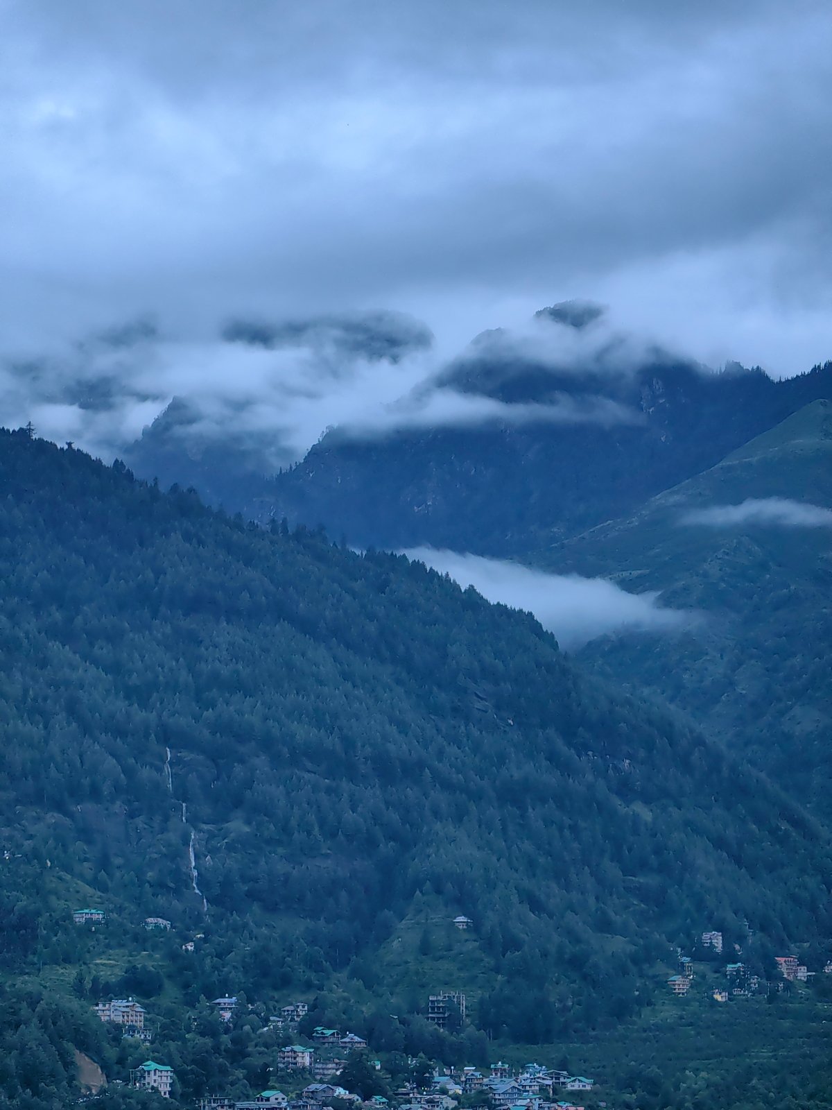 Vashisht village wrapped in mountain mist on an overcast evening