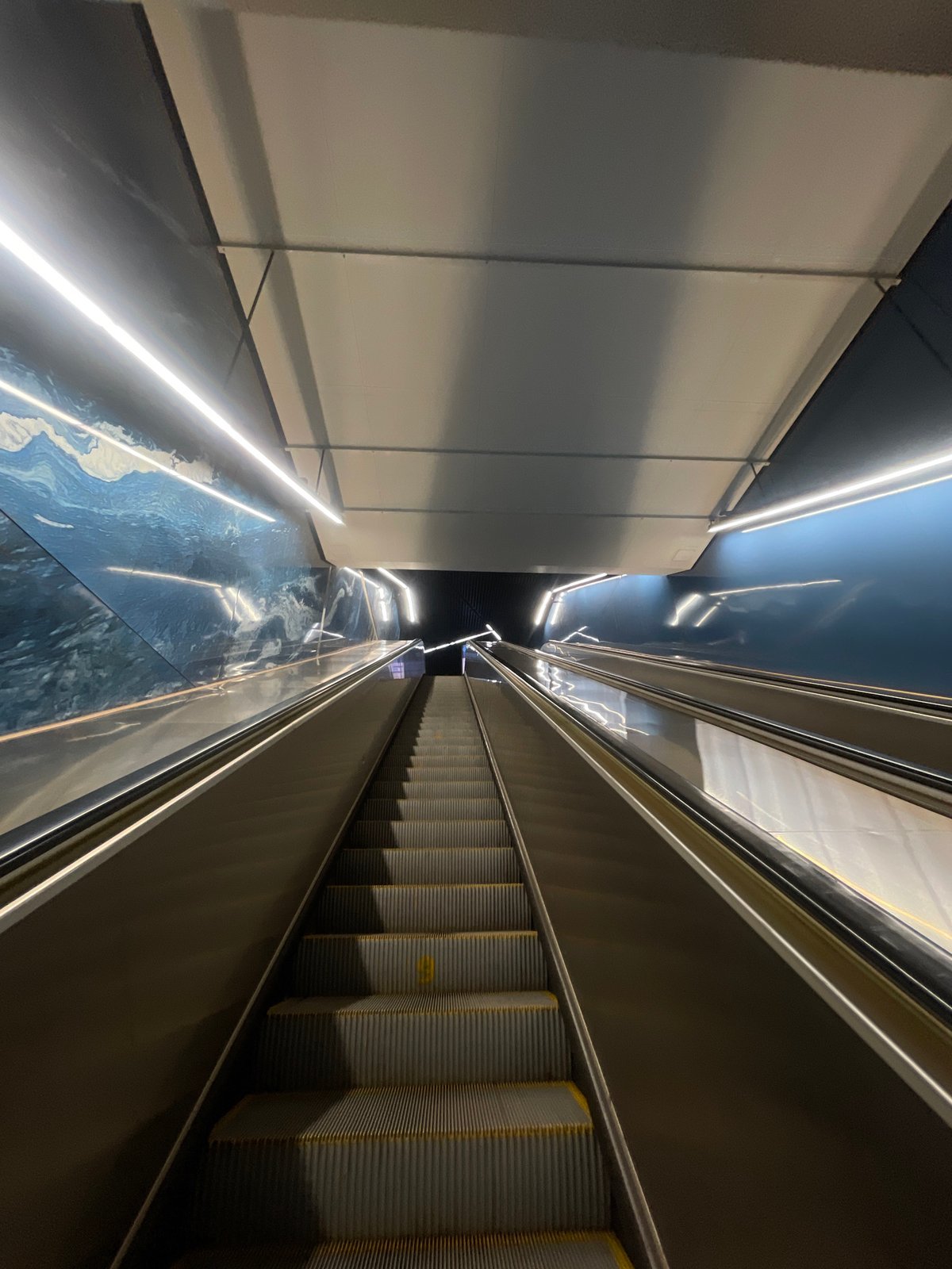 Subway escalators and a cable-stayed bridge on an urban afternoon