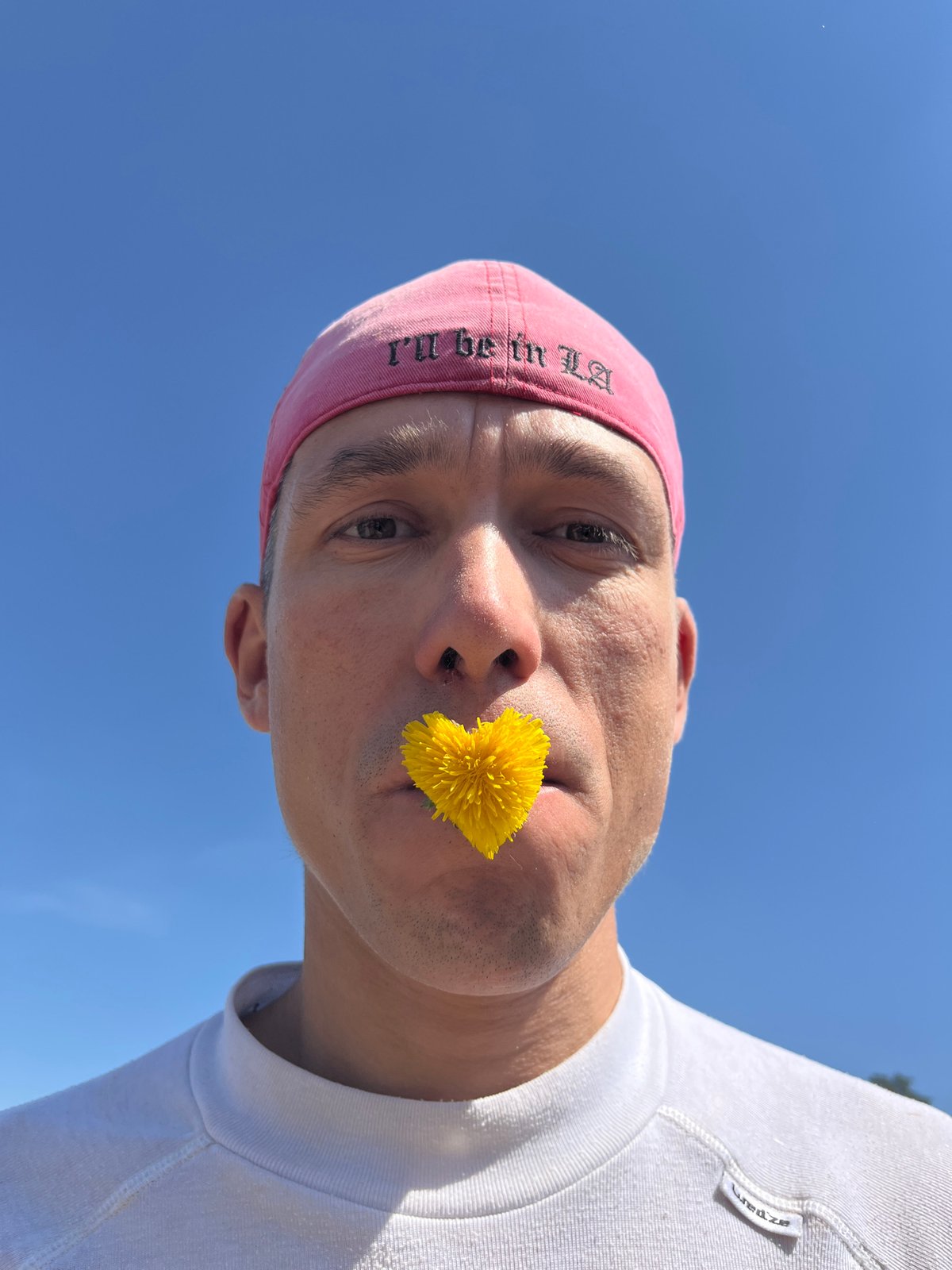 Man photographed from below with dandelion in Chaikovsky, Russia