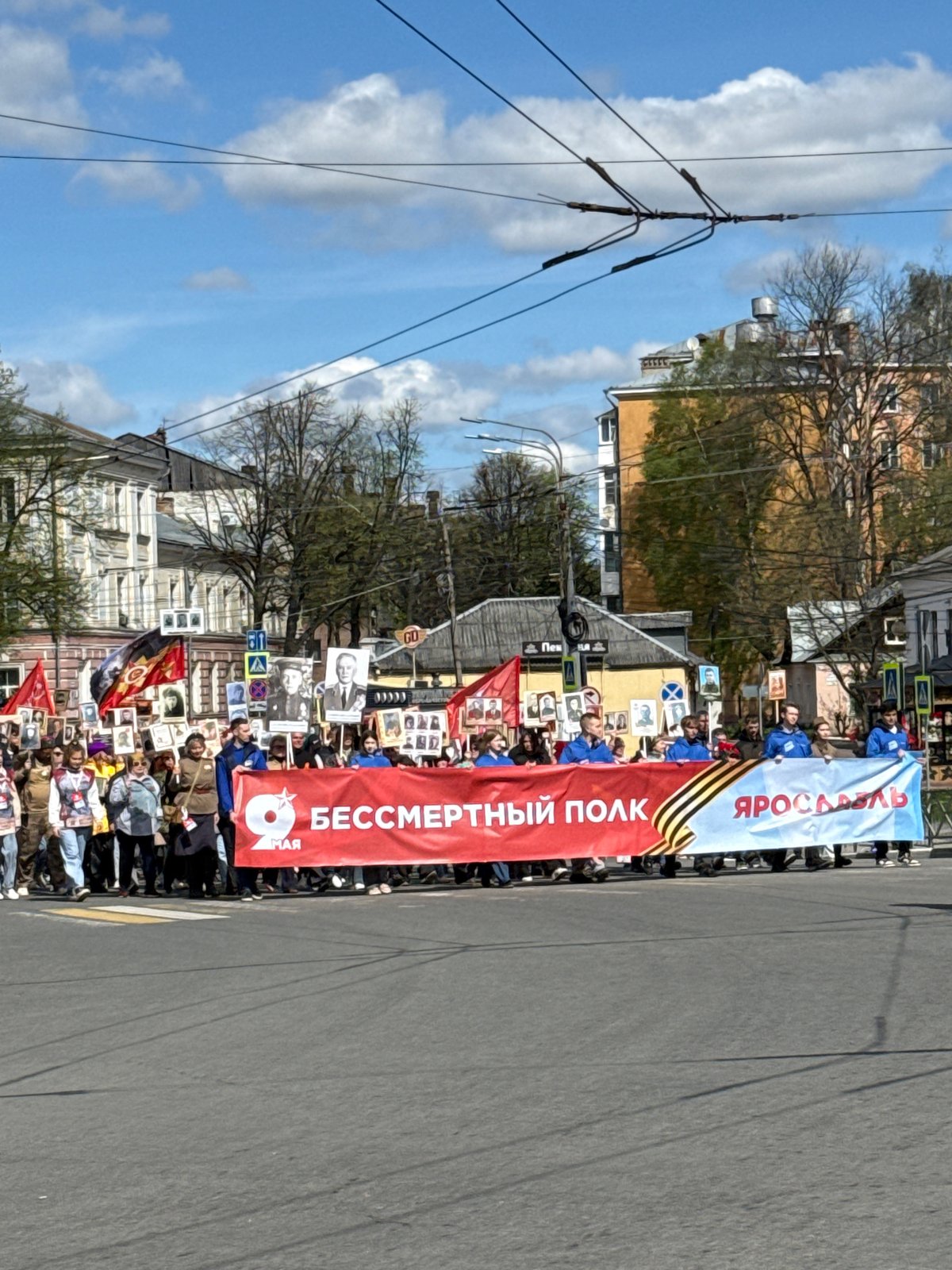 Street parade with banners, portraits held in Rusanovo, Russia