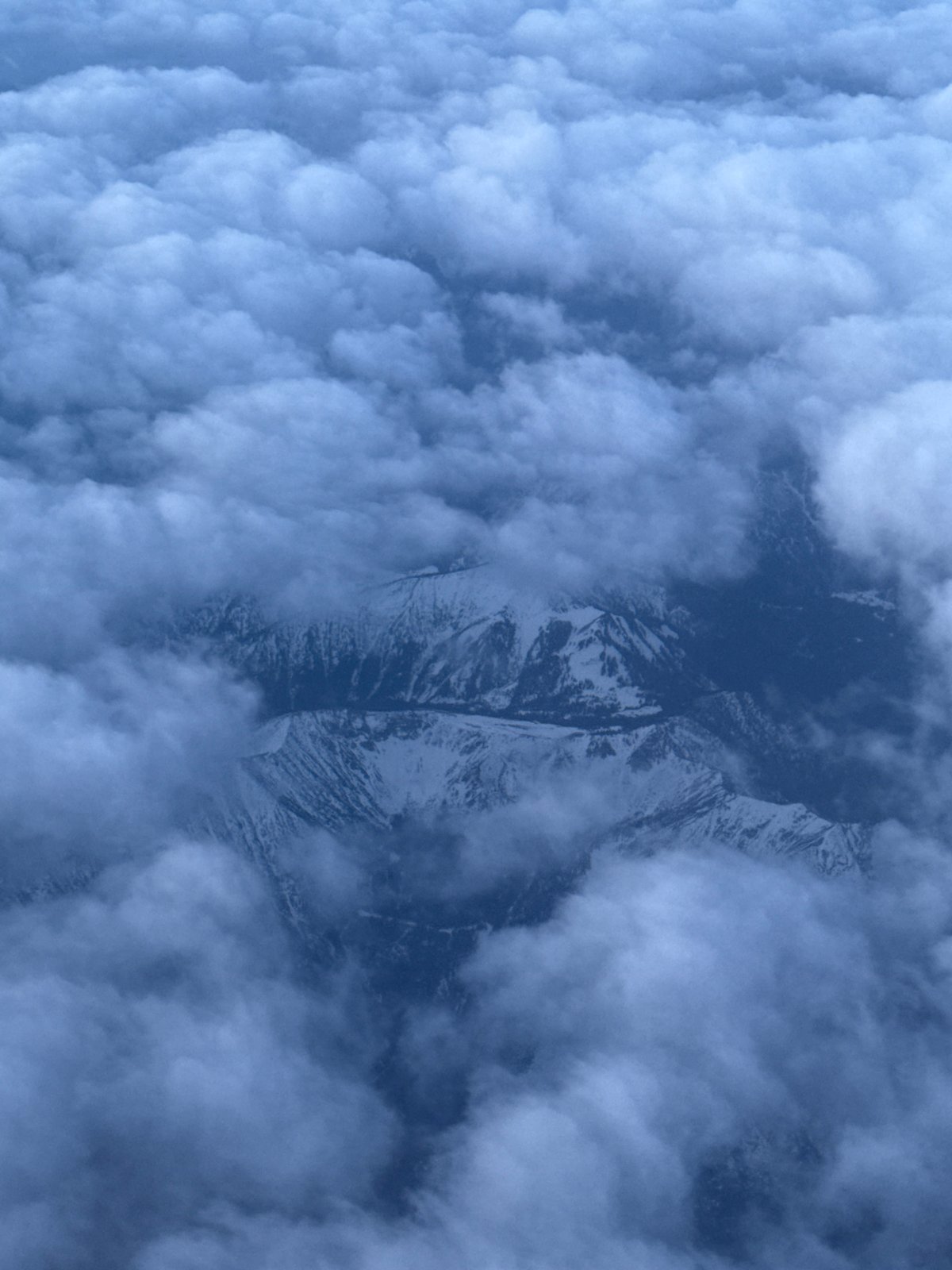 Early morning flight captures crescent moon over cloud-covered Sofia mountains
