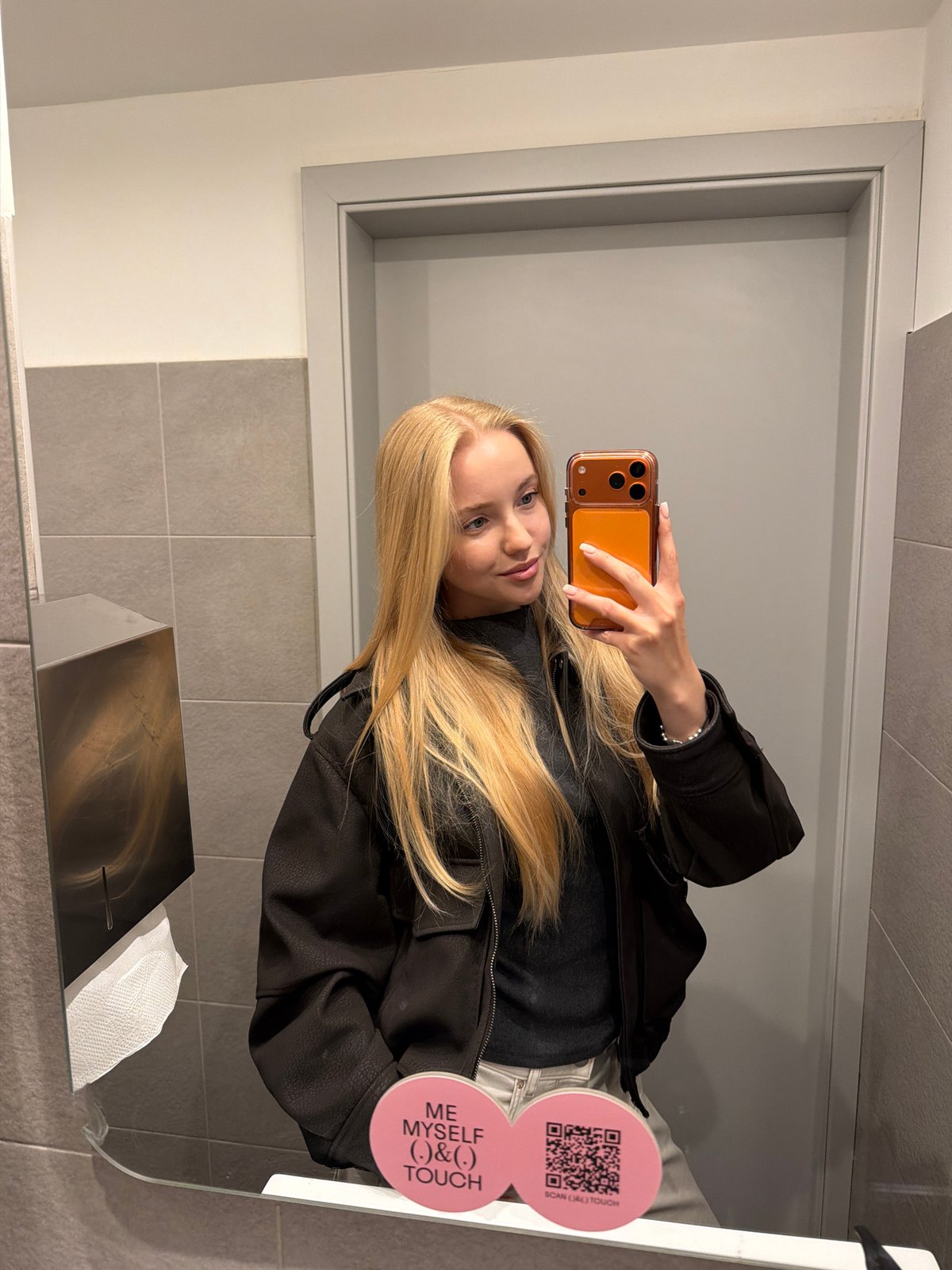 Woman takes selfies in restaurant bathroom during evening visit