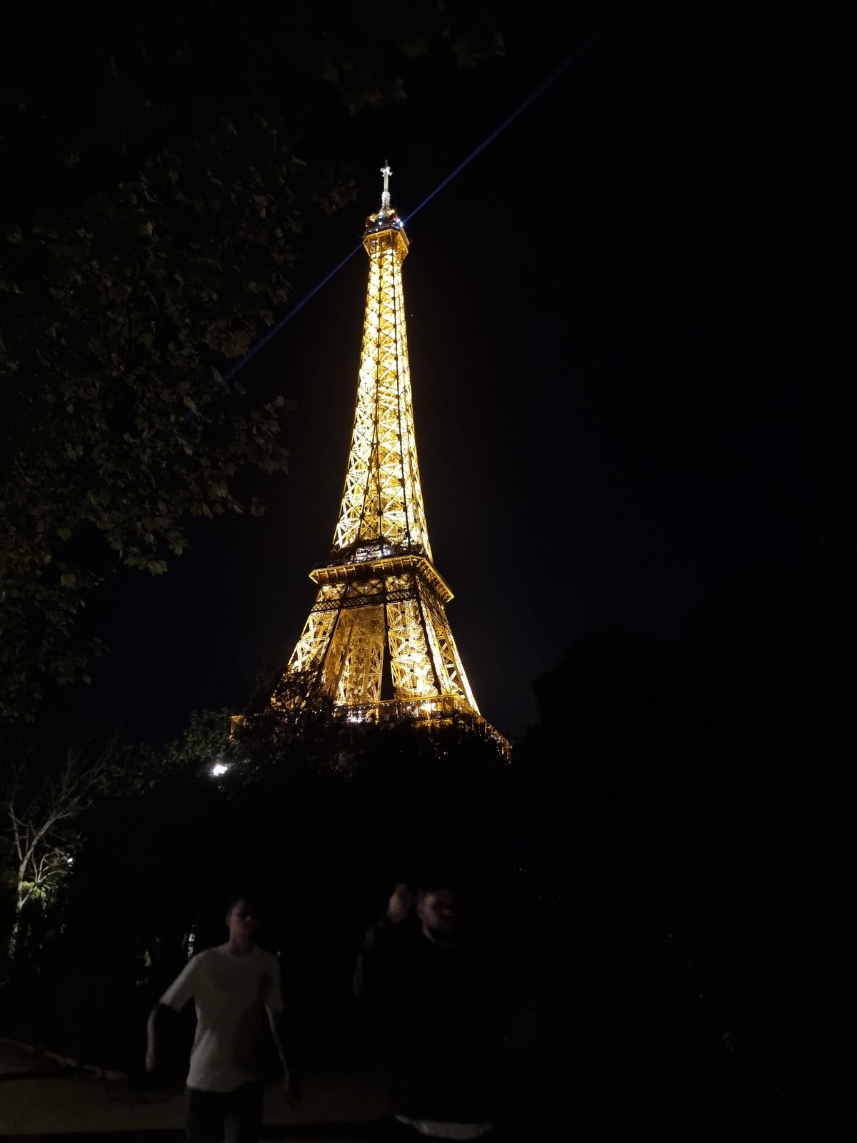 Eiffel Tower glows golden with blue beam Friday evening