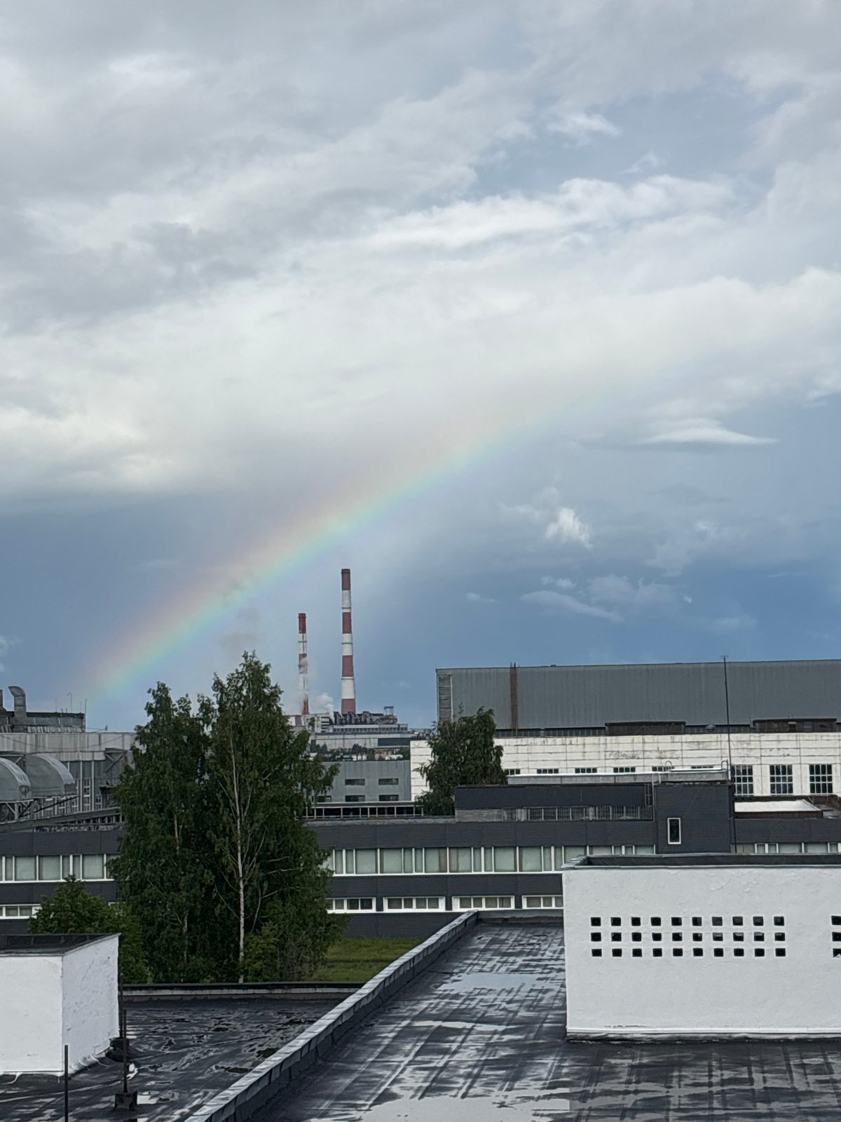 Rainbow brightens industrial Izhevsk skyline amid cloudy afternoon