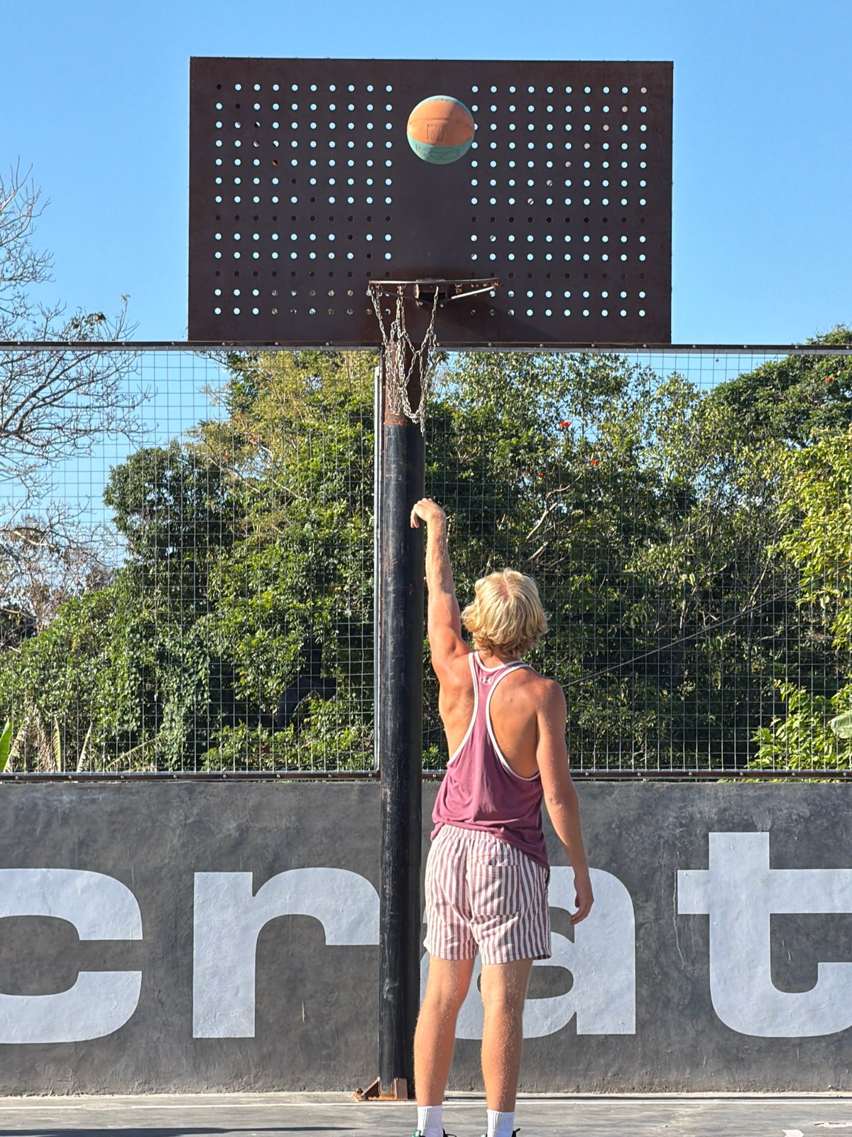 Outdoor basketball in Mengwi with a kite overhead