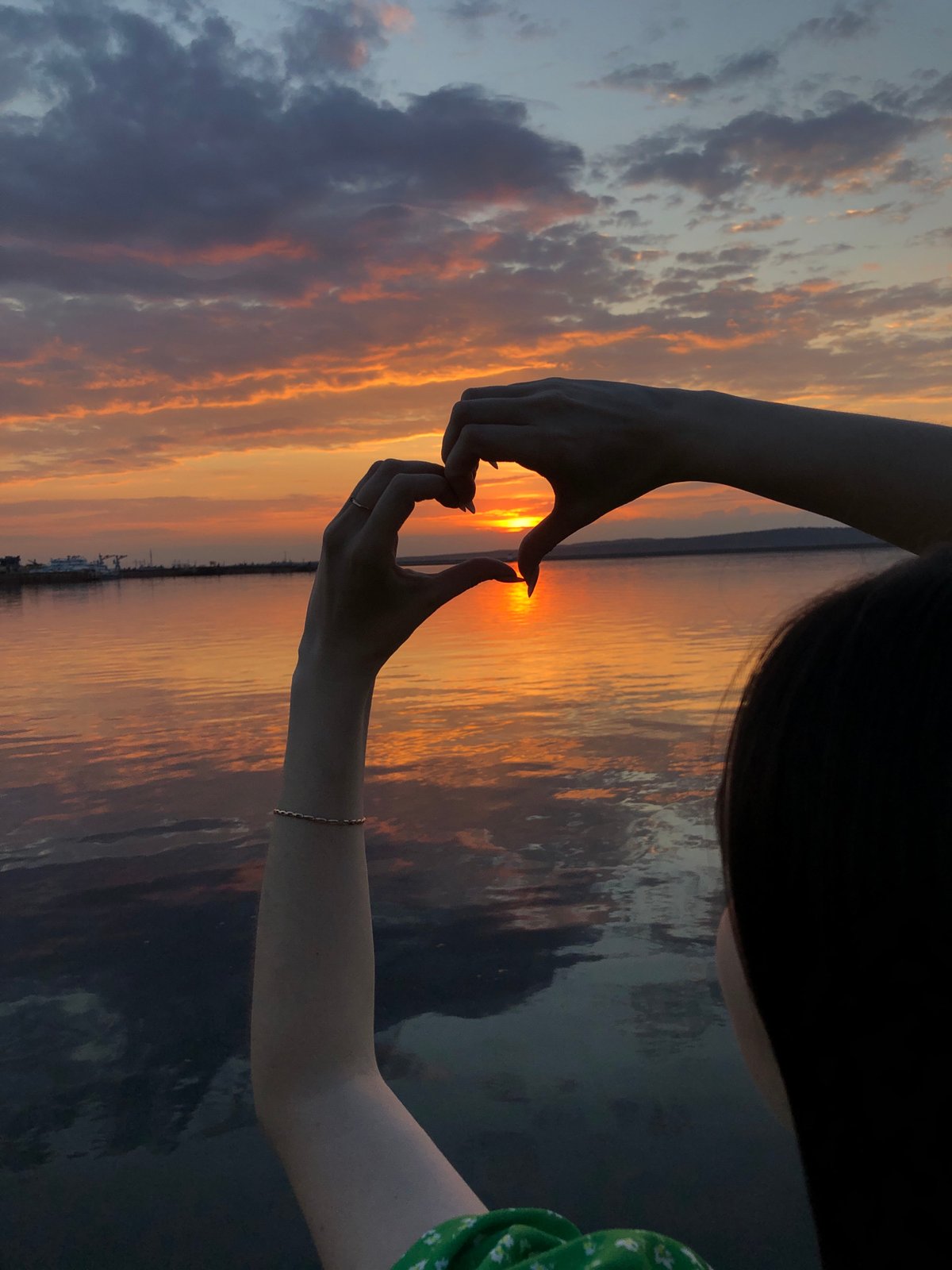 Woman photographs sunset moment along Kama River in Chaikovsky