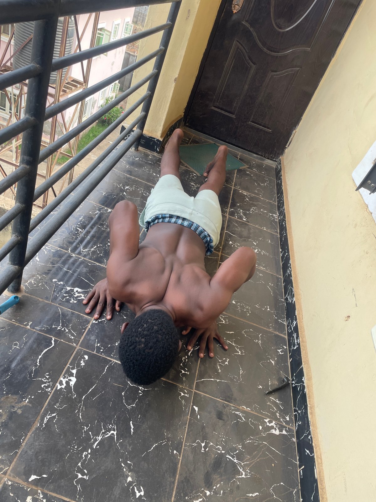 Man performs morning workout routine on Abuja balcony