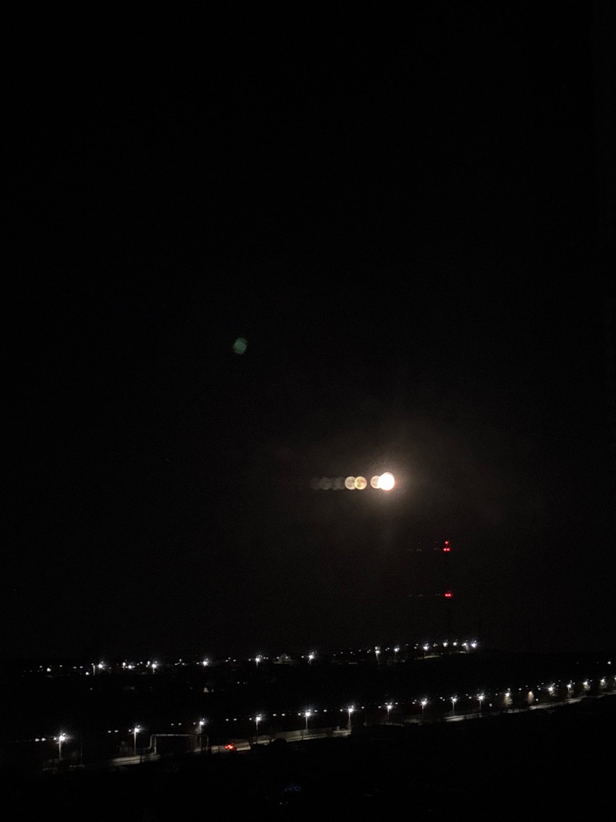 Moonlit evening scene captured along illuminated waterfront in Chaikovsky