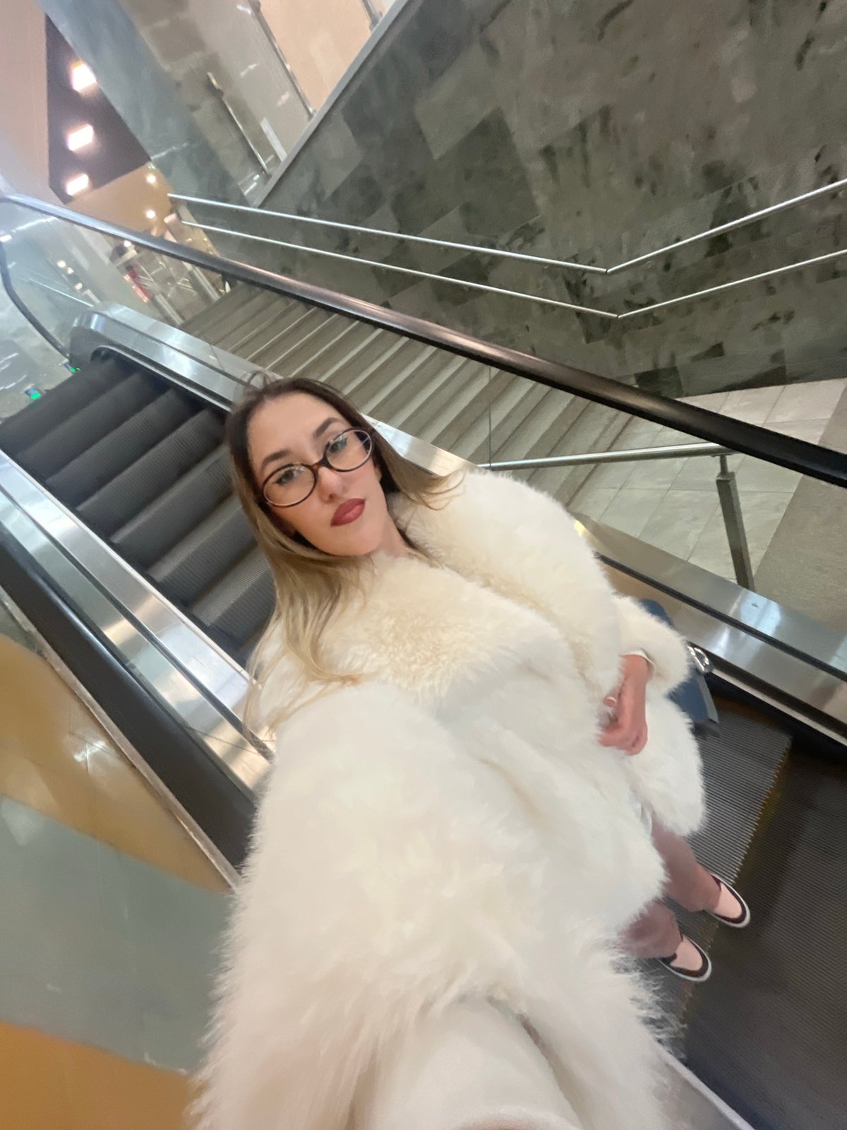 Woman rides escalator in Sofia shopping center
