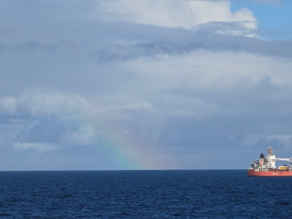 Rainbow appears over Norwegian waters as vessel navigates coastline