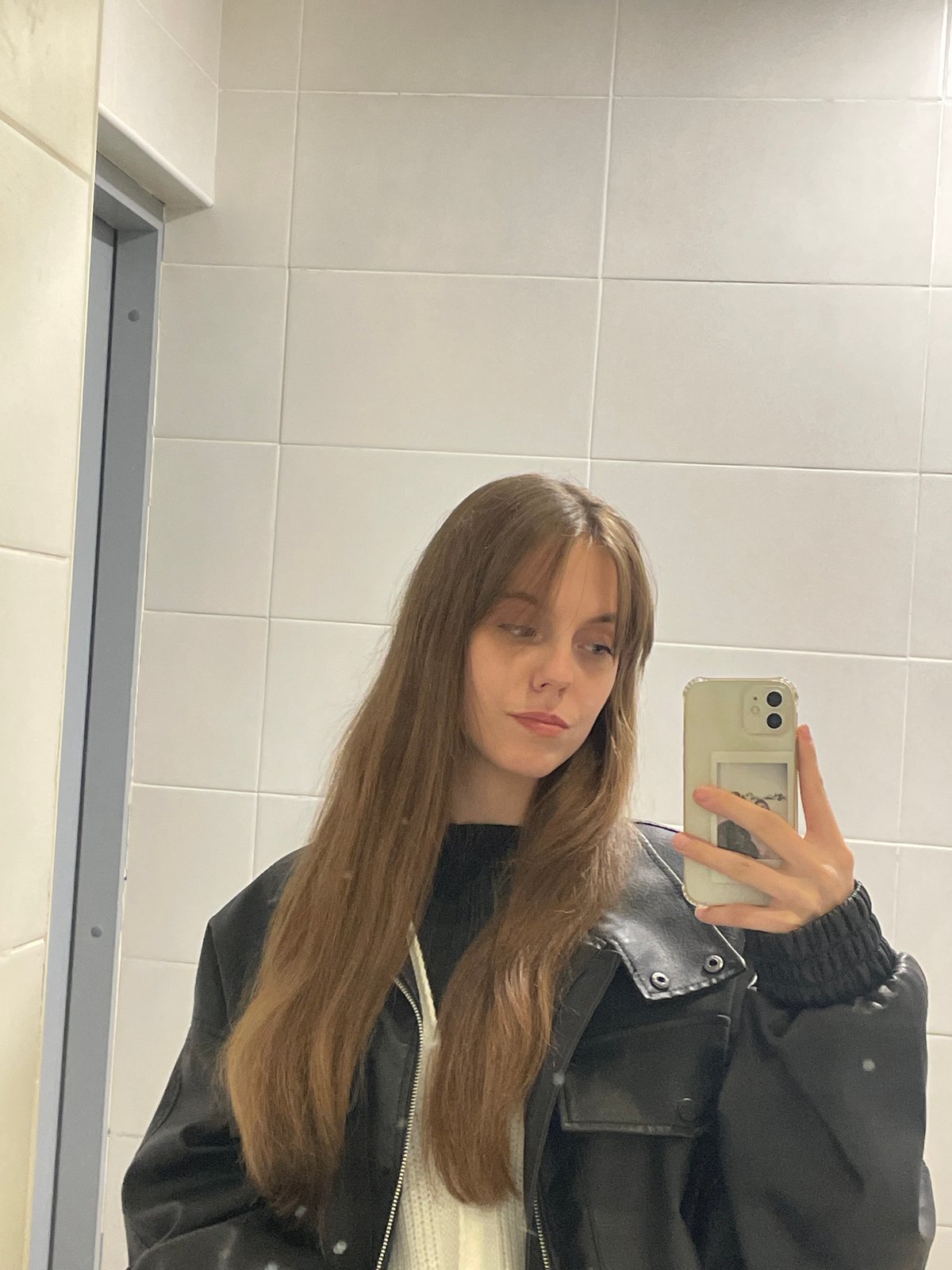 Woman takes mirror selfie in Ufa restroom