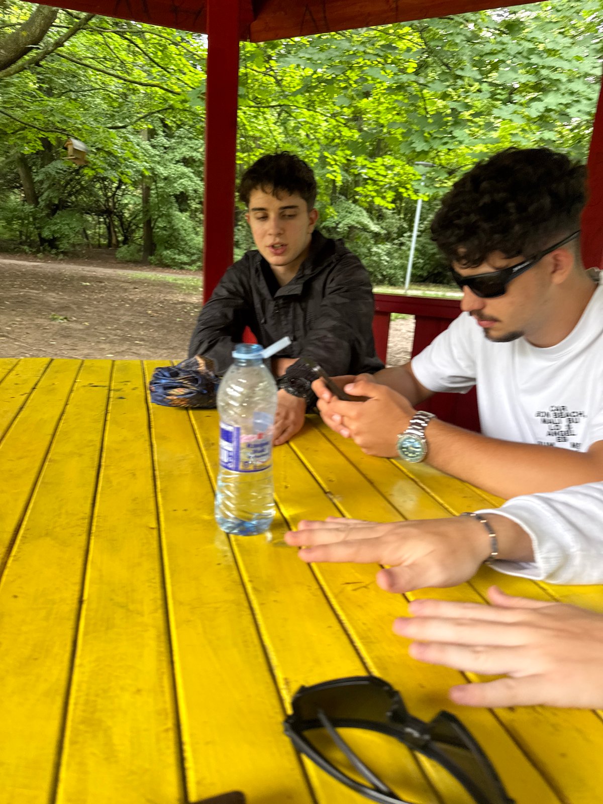 Three people meet at yellow table in Sofia park