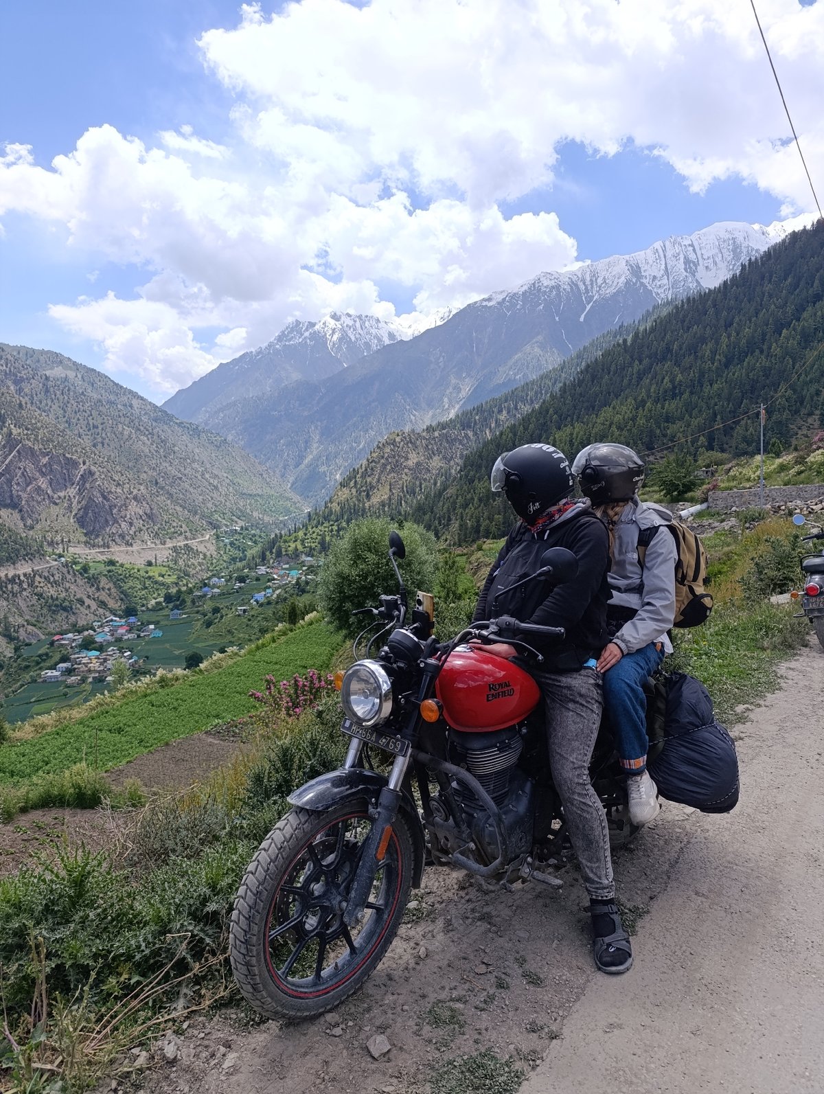 Red Royal Enfield with two riders in Kishori, India