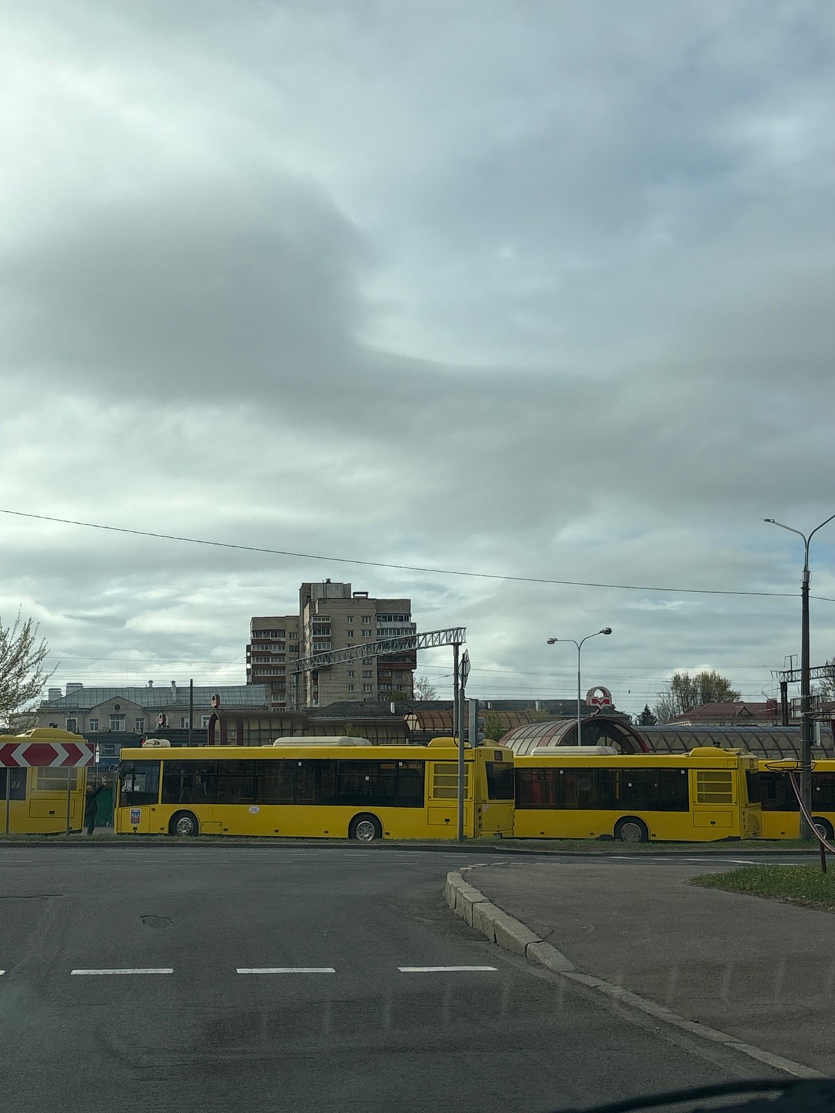Morning street scene captured with woman in car, buses in Minsk