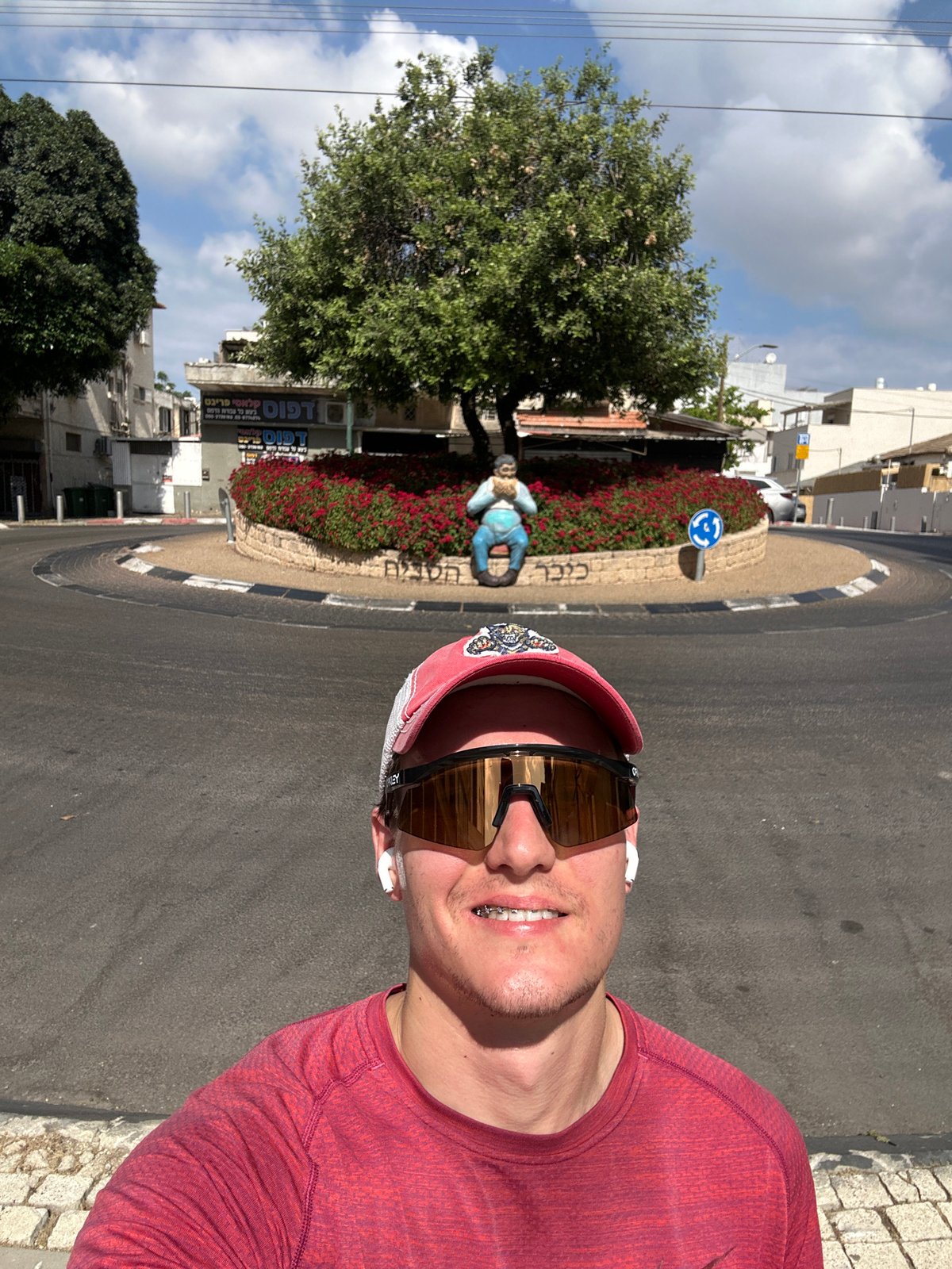 Man takes morning selfie near decorated roundabout in Ramat Gan
